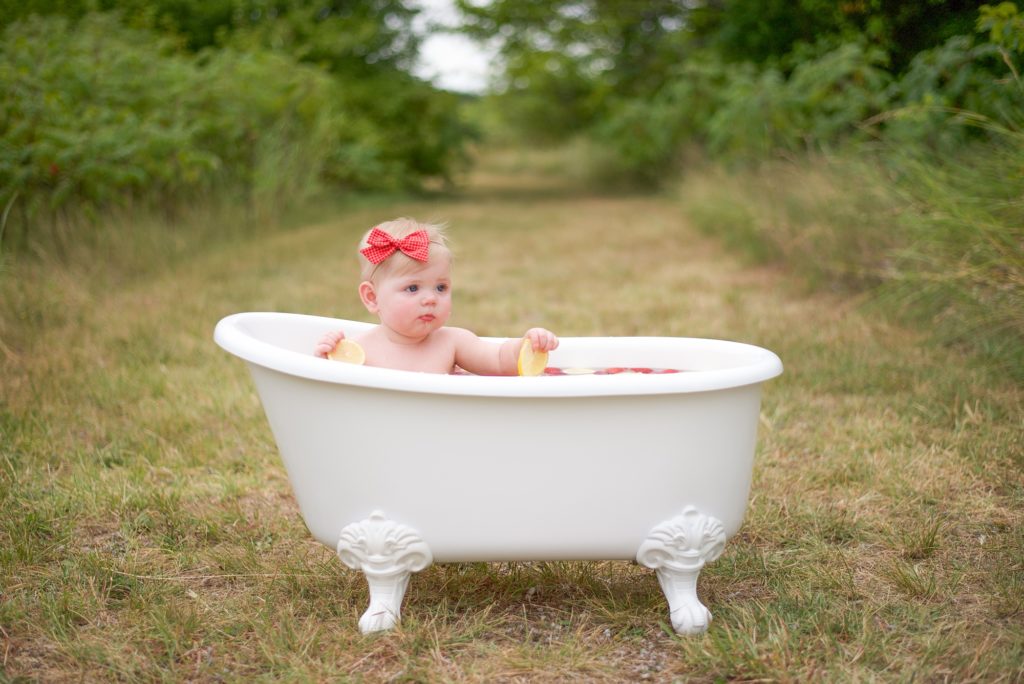baby girl plays in tub during Texas milestone photos