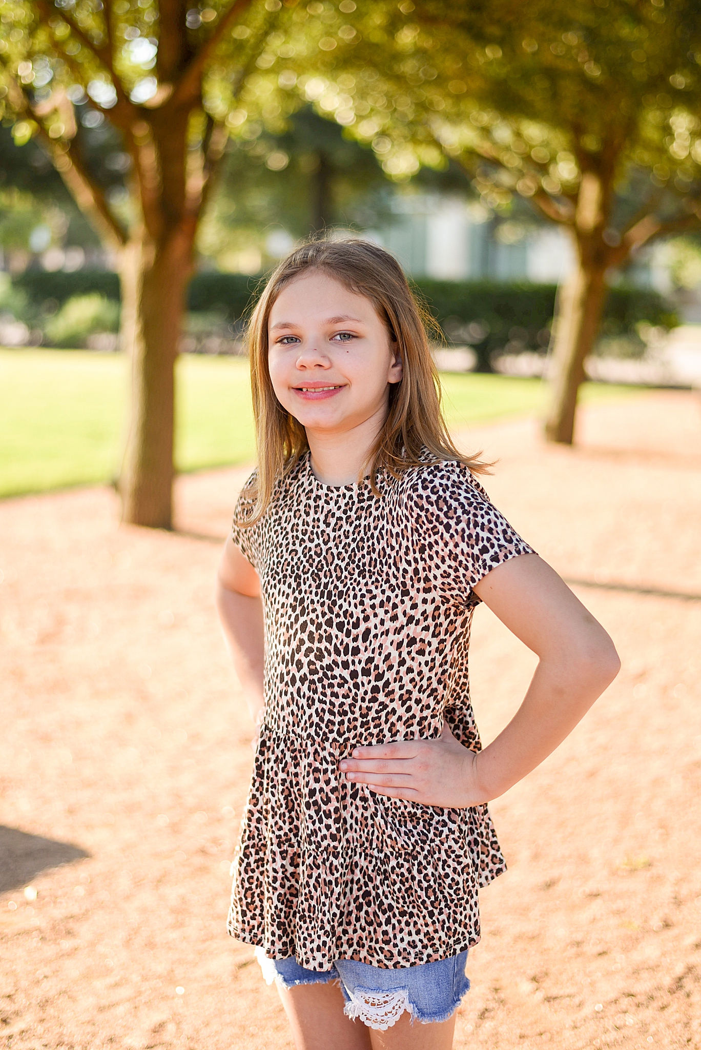 oldest daughter in leopard print poses on playground