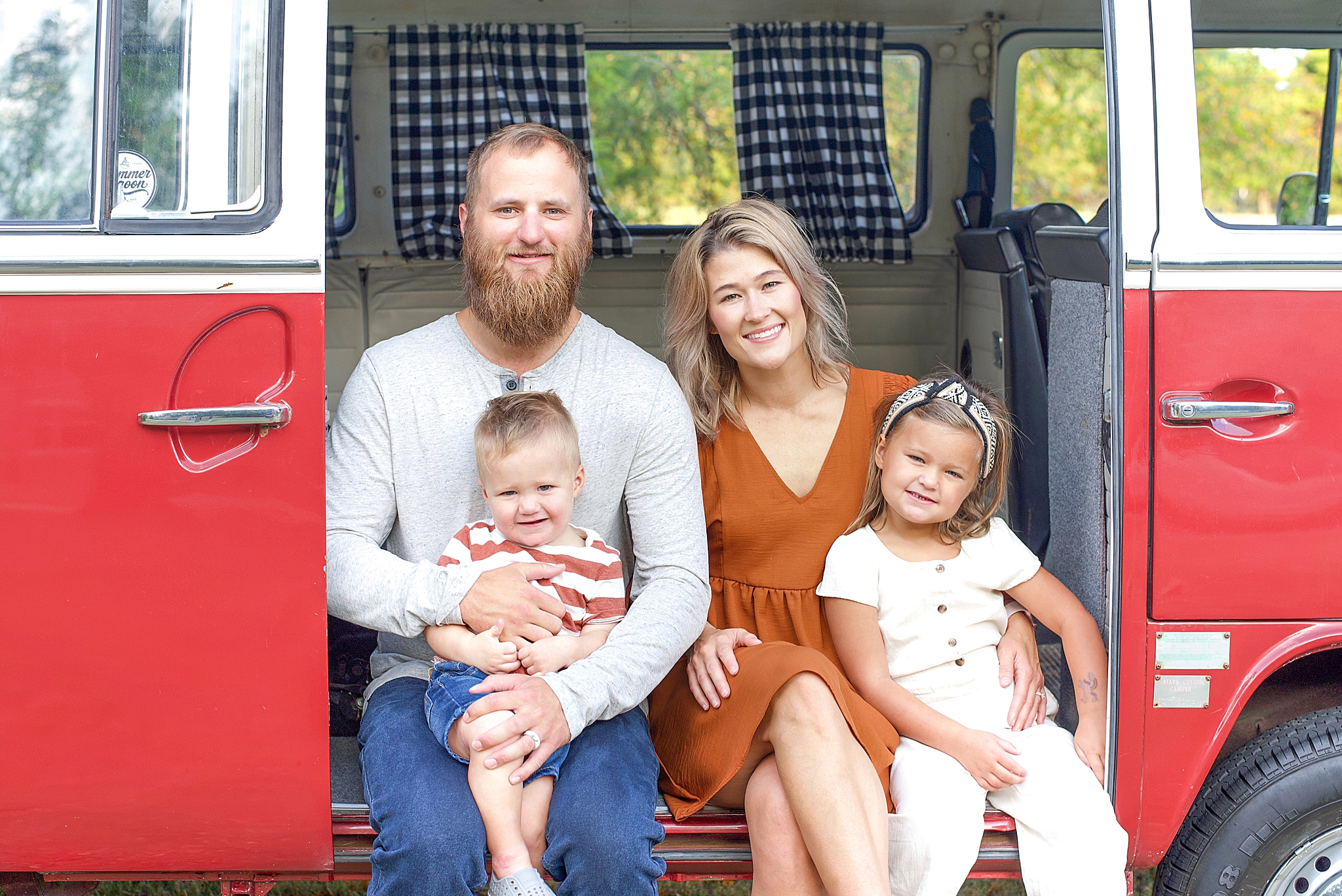 family of four poses in VW van during family photos in Little Elm
