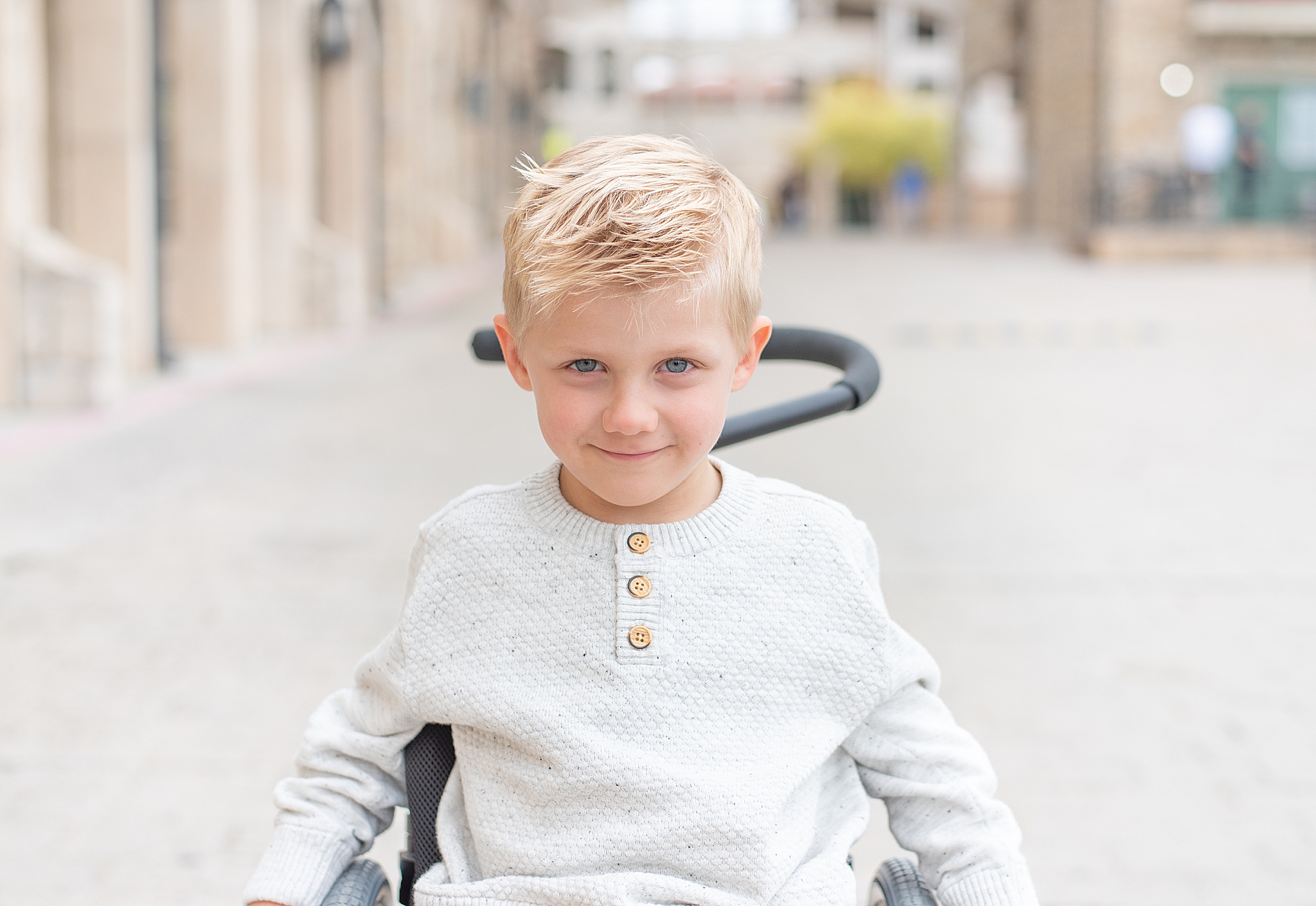young boy in wheelchair poses during Adriatica Village family portraits