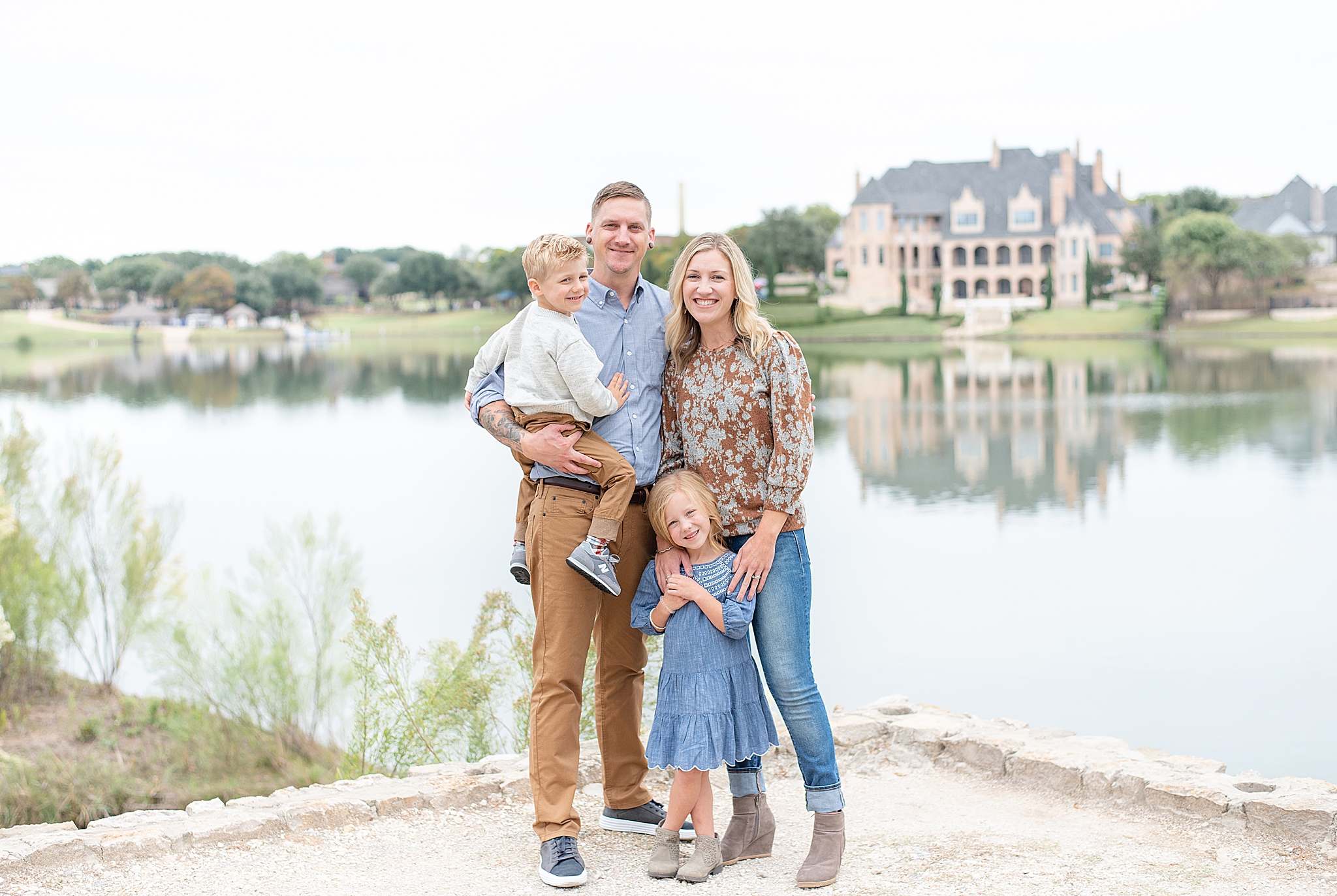 family of four poses by Texas waterfront during family photos