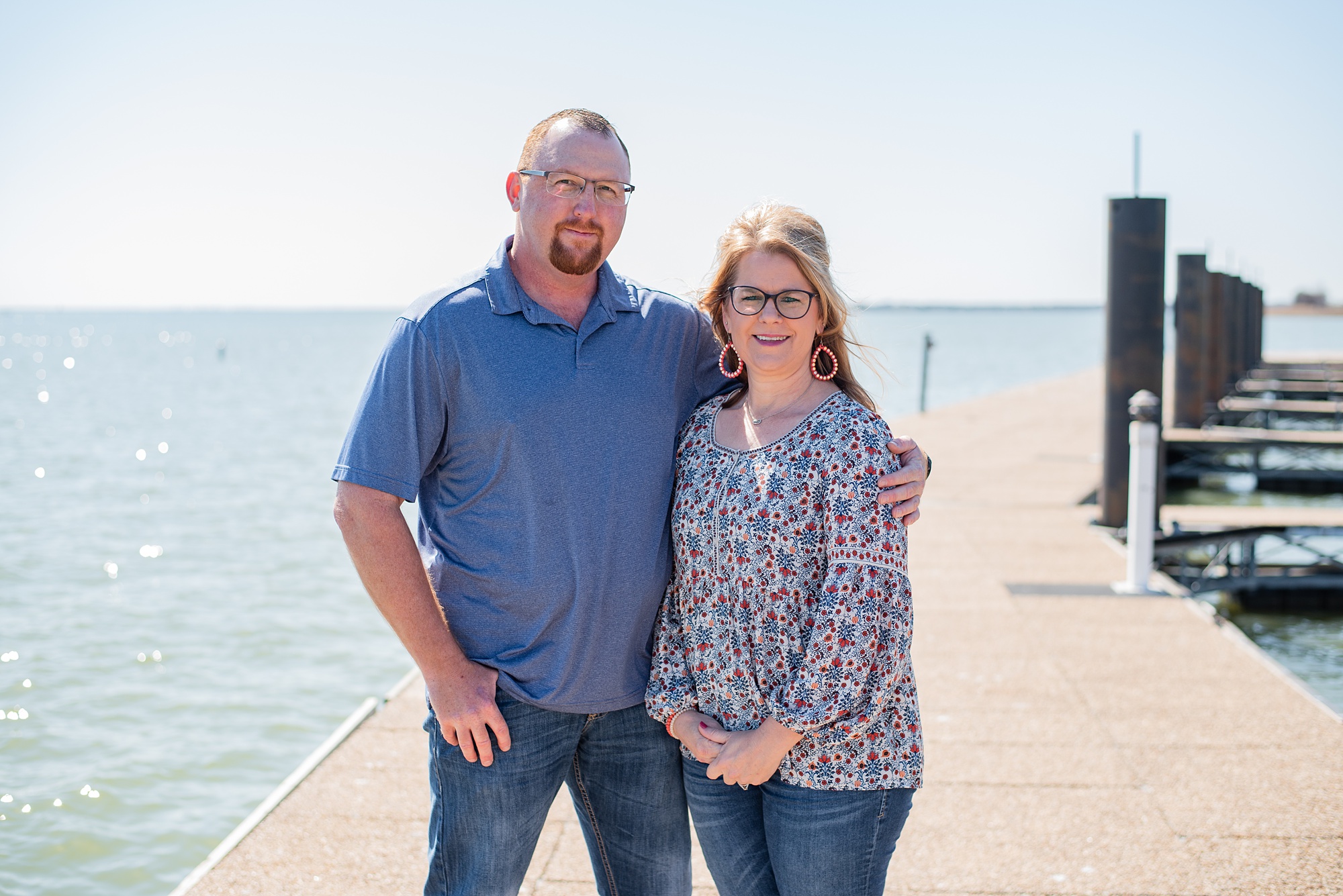husband and wife pose along water during Garland TX extended family session