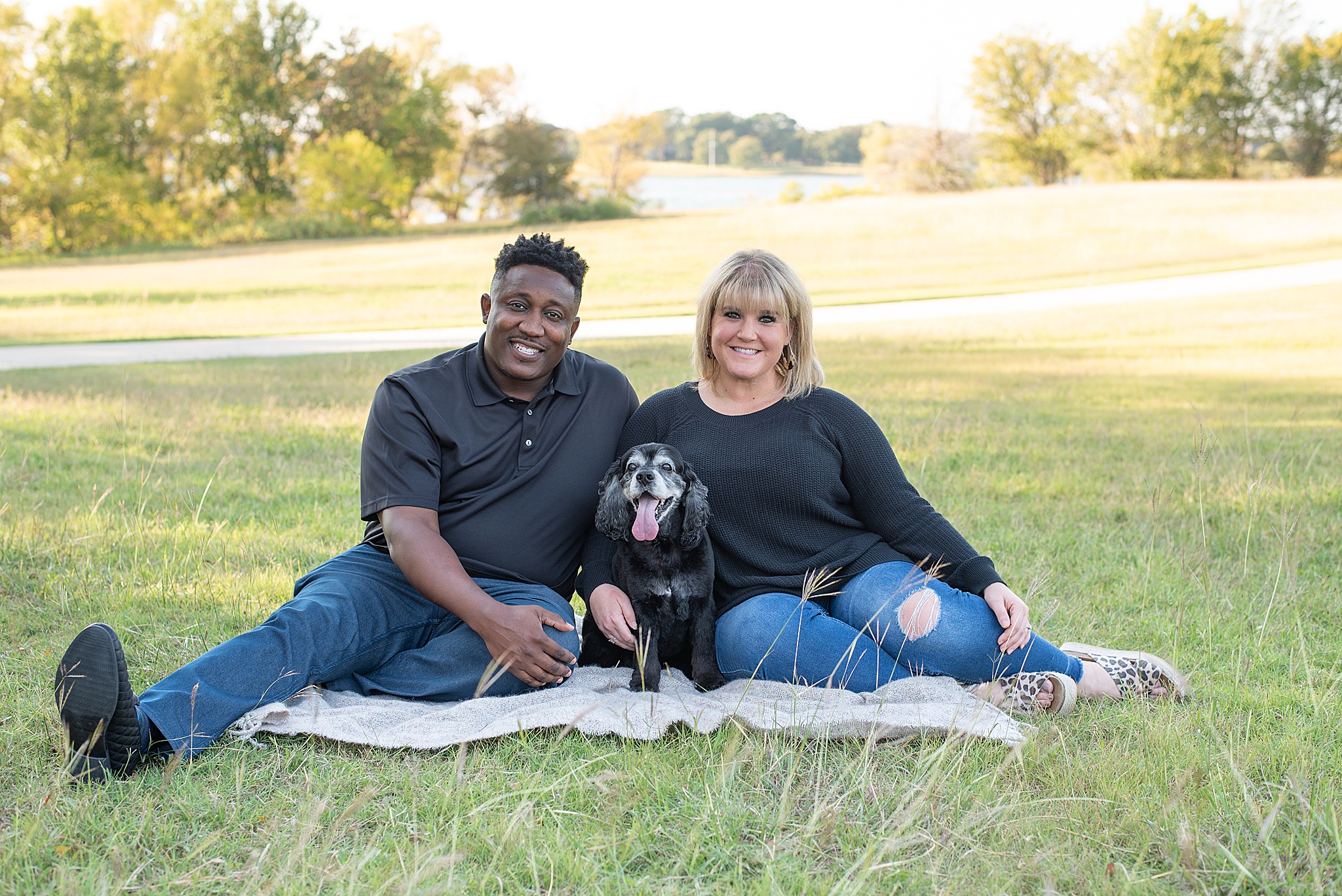 couple sits with dog on blanket in Little Elm Park