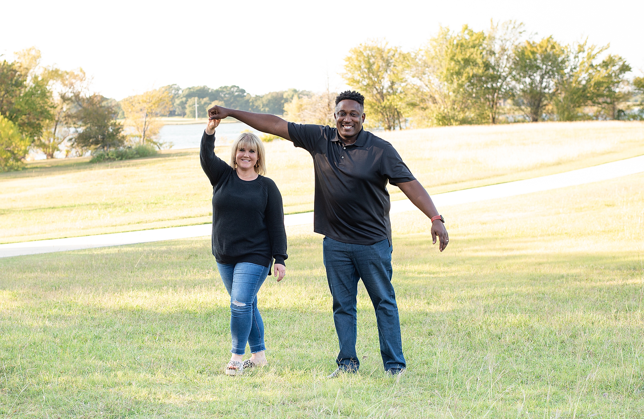 husband twirls wife during Little Elm Park family photos