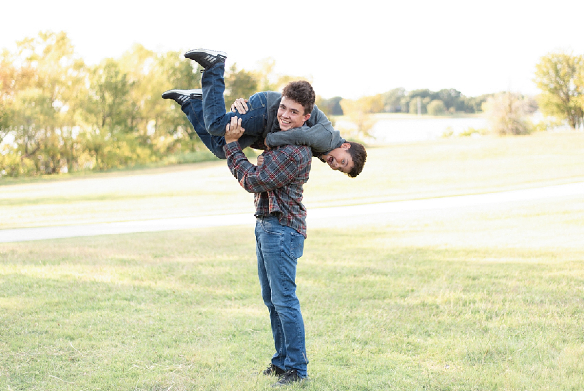 big brother lifts little brother over his shoulder during family photos