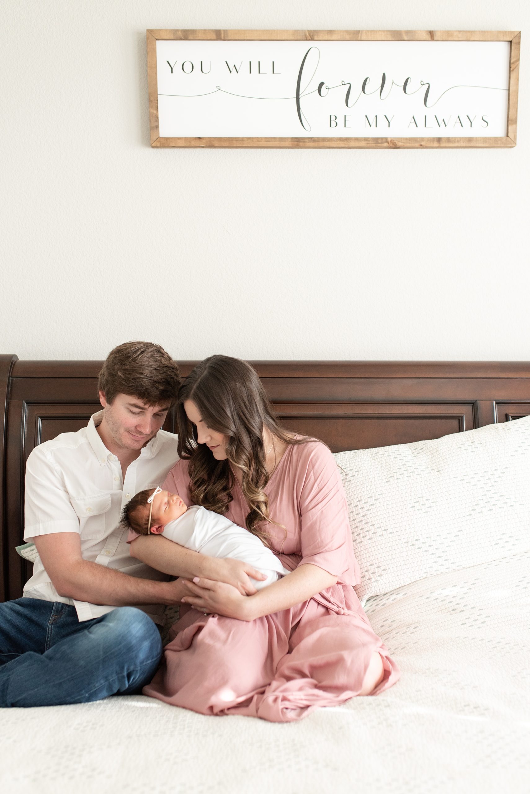 parents snuggle baby girl in bed during Aubrey TX lifestyle newborn session 
