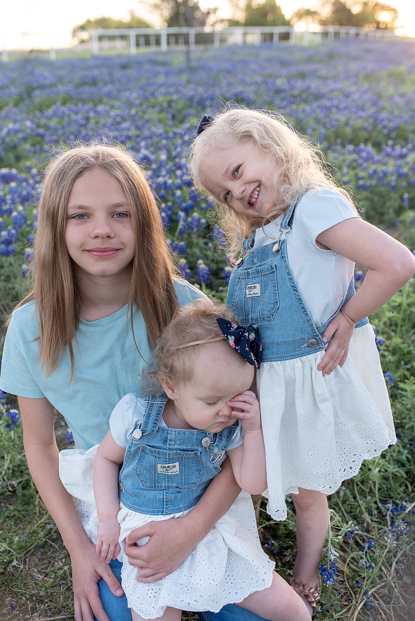 three girls sit together during bluebonnet mini sessions