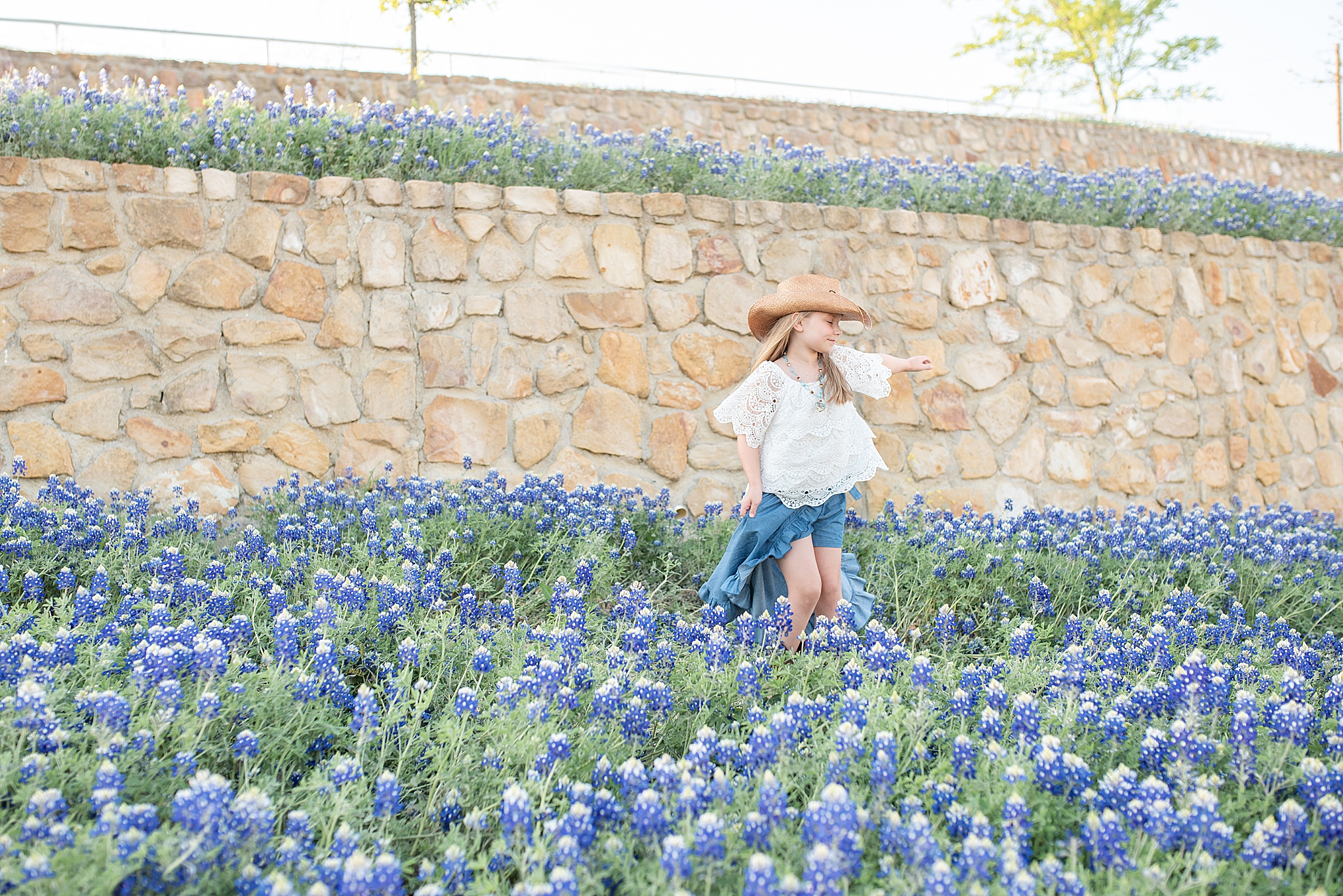 girl plays in field of bluebonnets in Texas