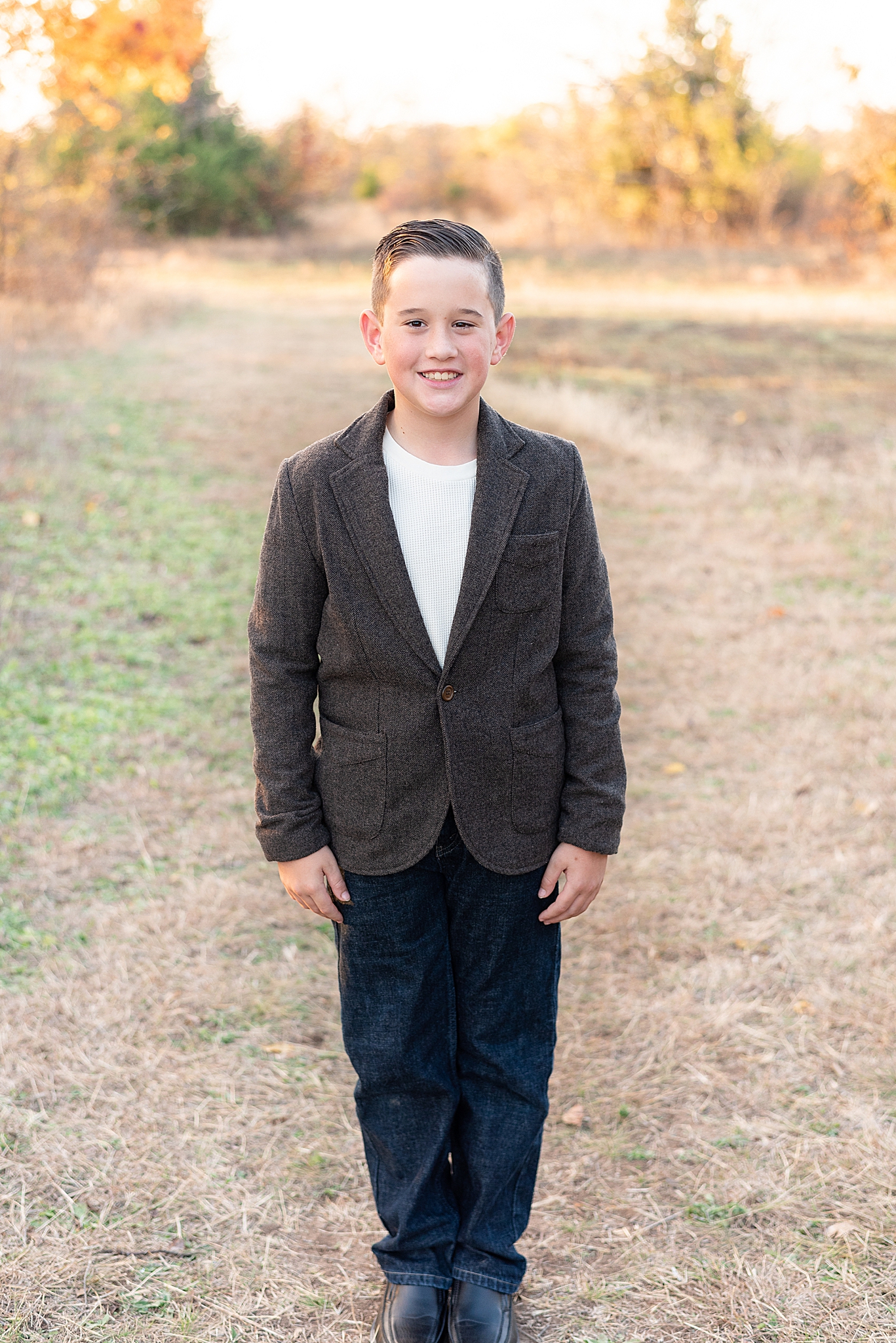 son poses in suede jacket during fall family photos