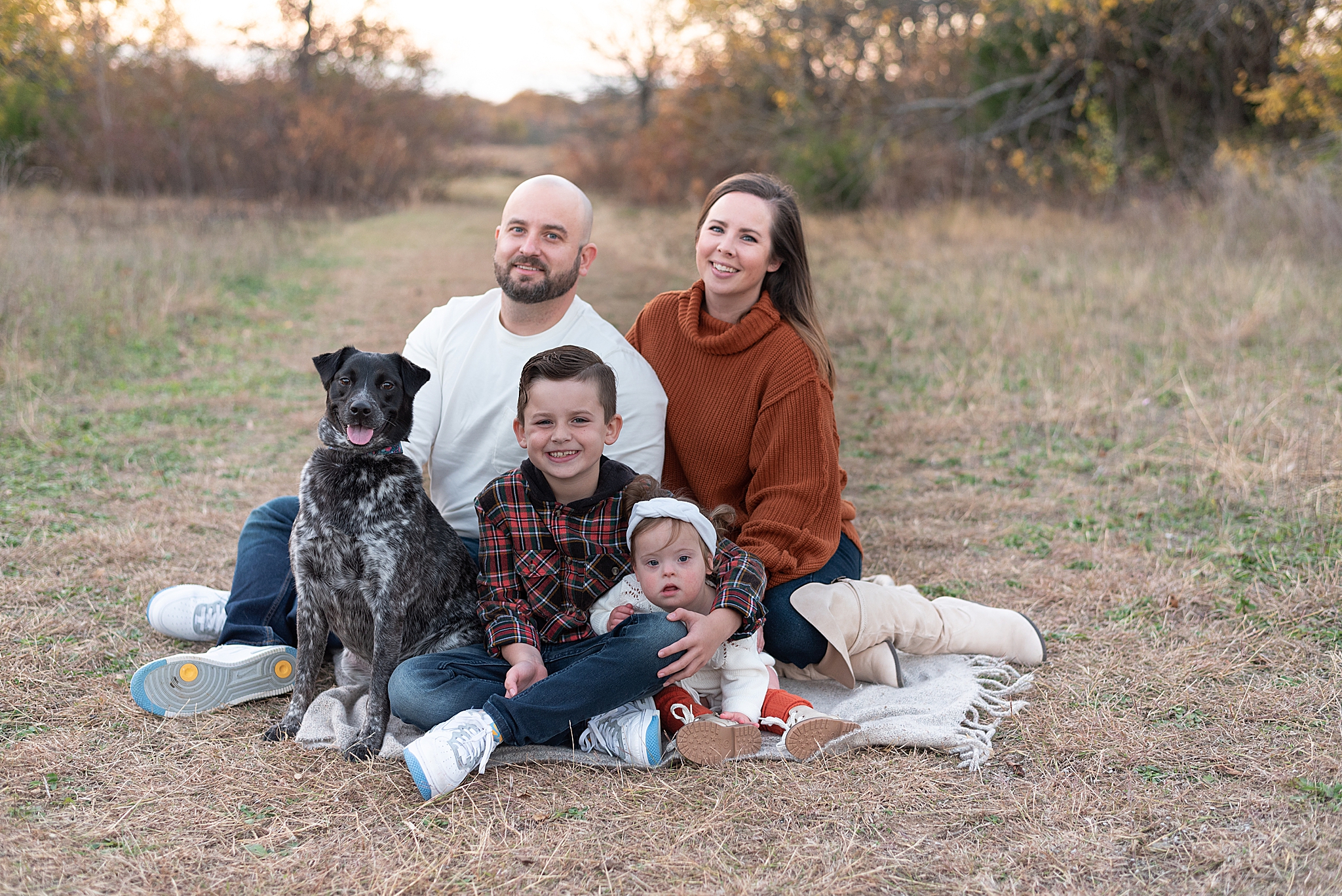 family of four poses with dog