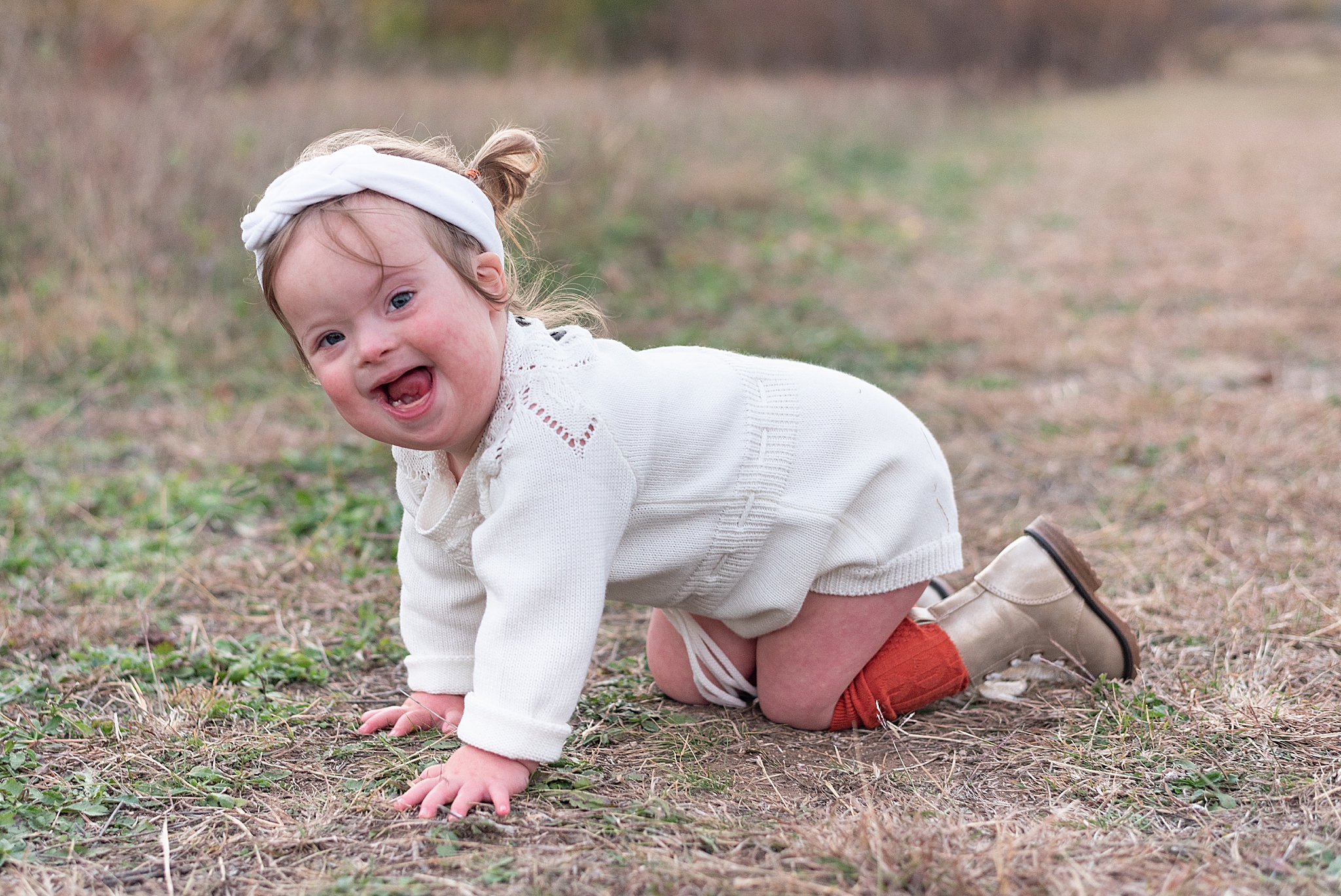 toddler with Down syndrome crawls in grass