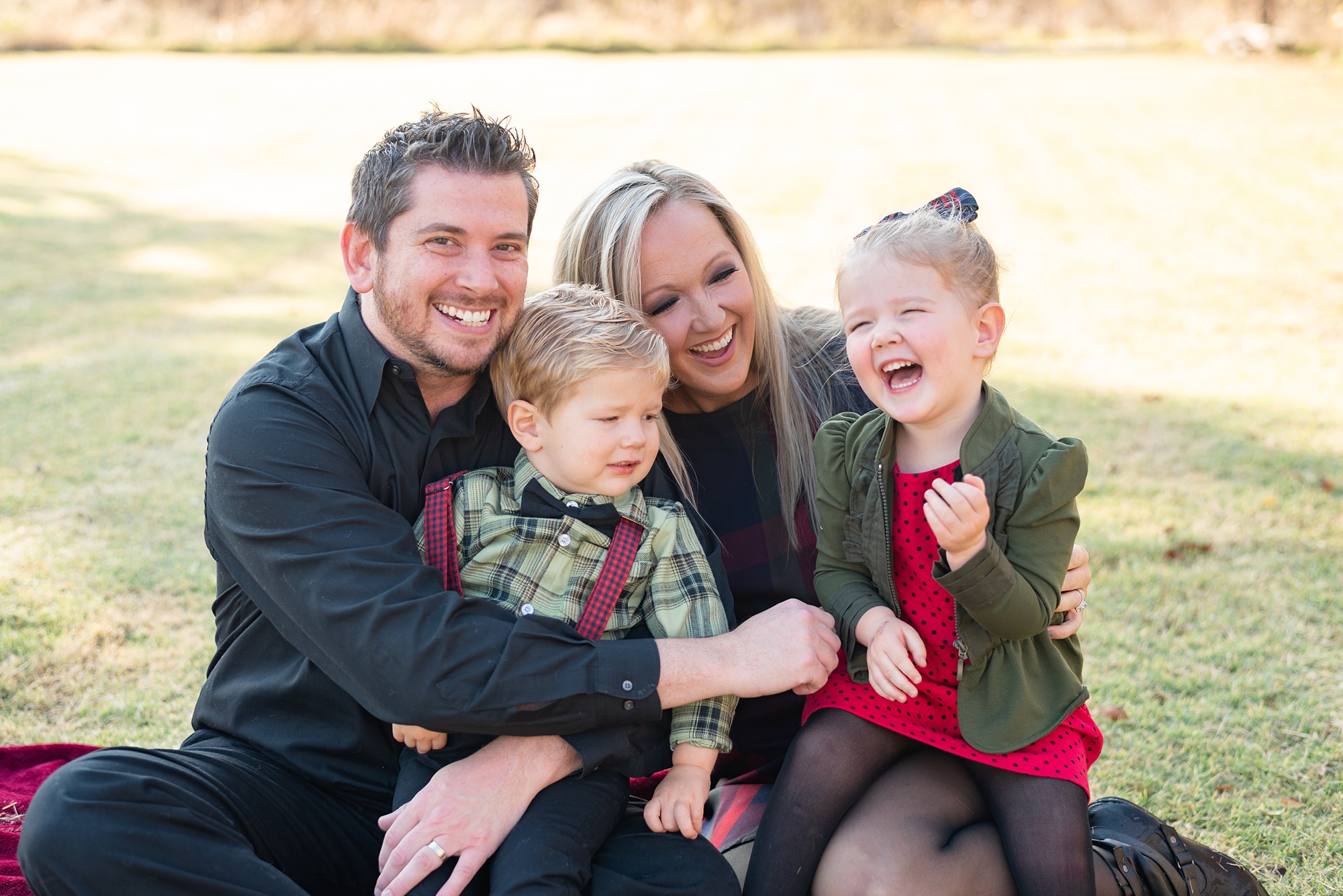 family of four laughs together during Little Elm backyard family portraits