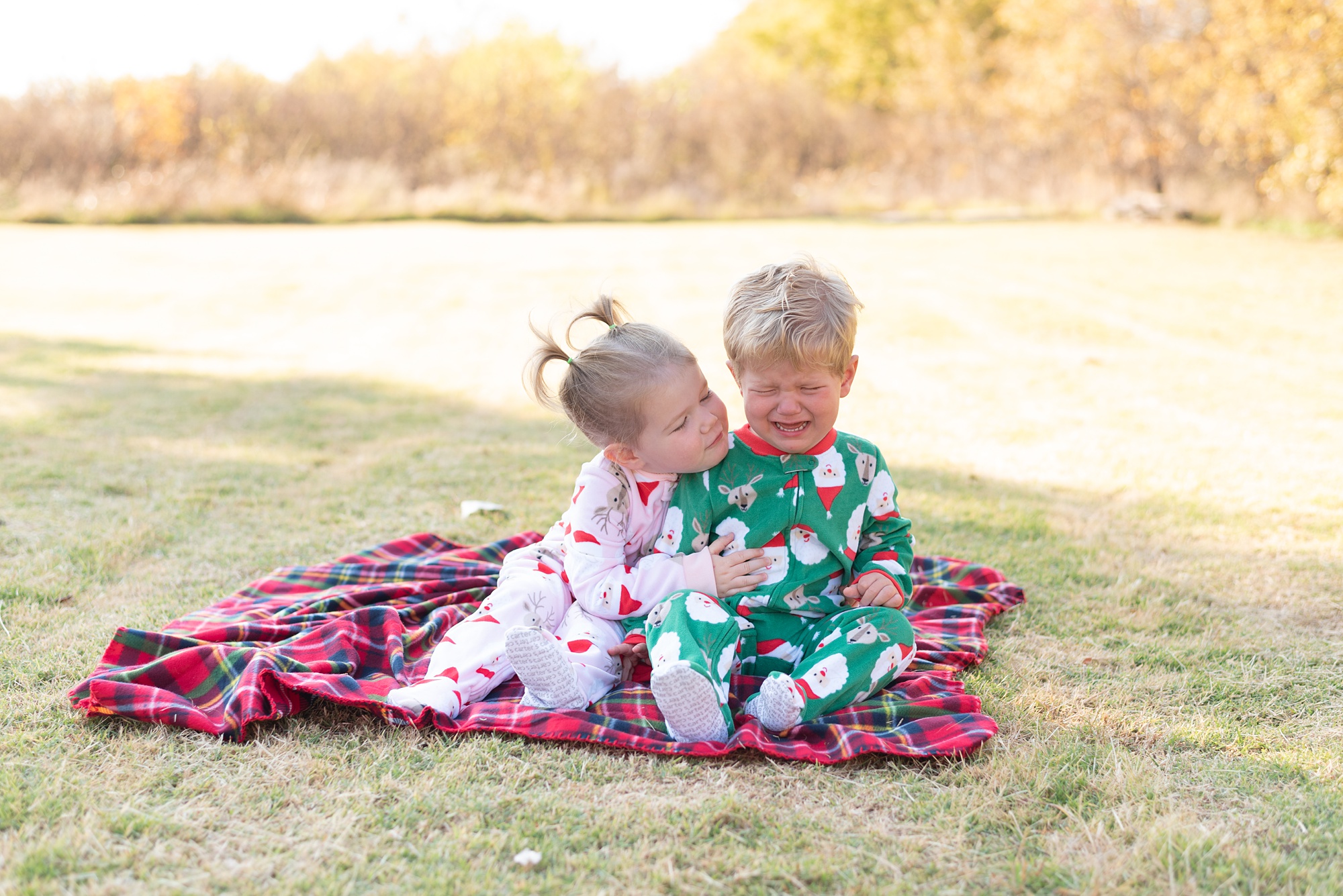 sister hugs brother in Christmas pajamas