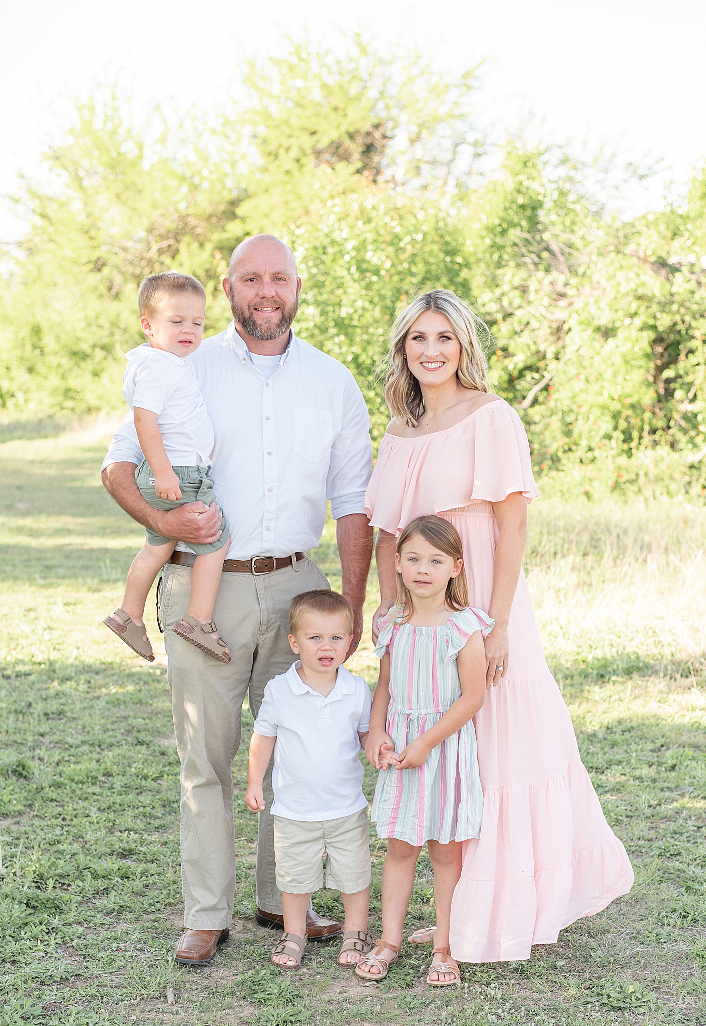 family of five poses in Frisco TX field