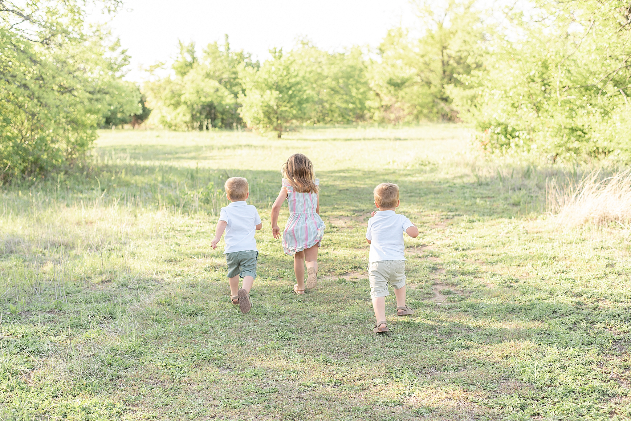three kids run in Frisco Field