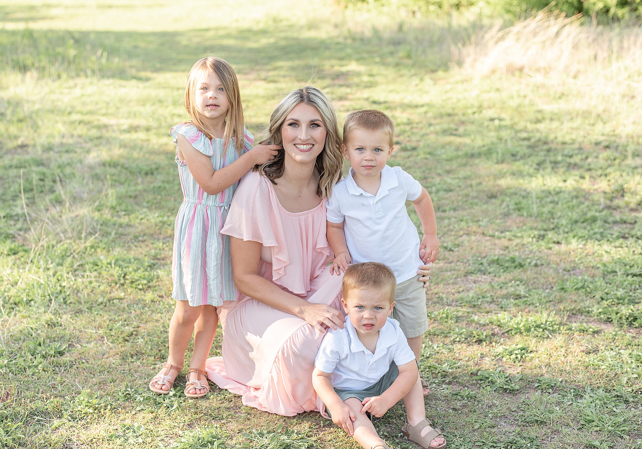 mom poses with three kids in Frisco Field 