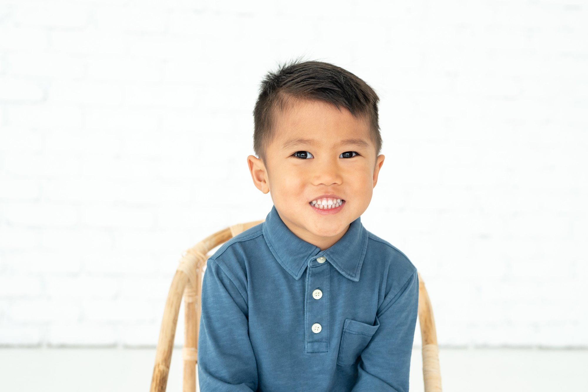 toddler sits on chair in blue polo