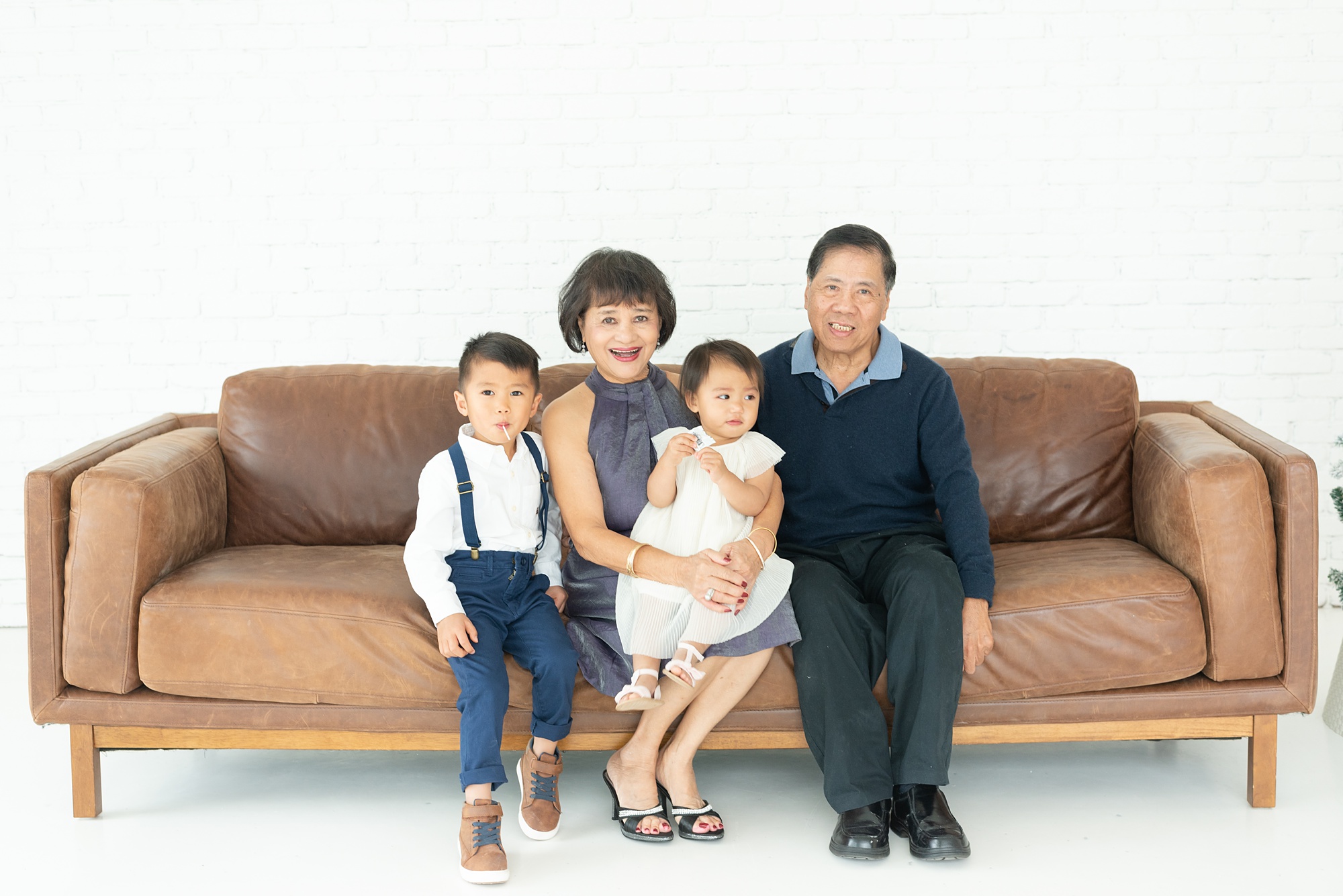 grandparents sit with grandchildren on couch in the Lumen Room