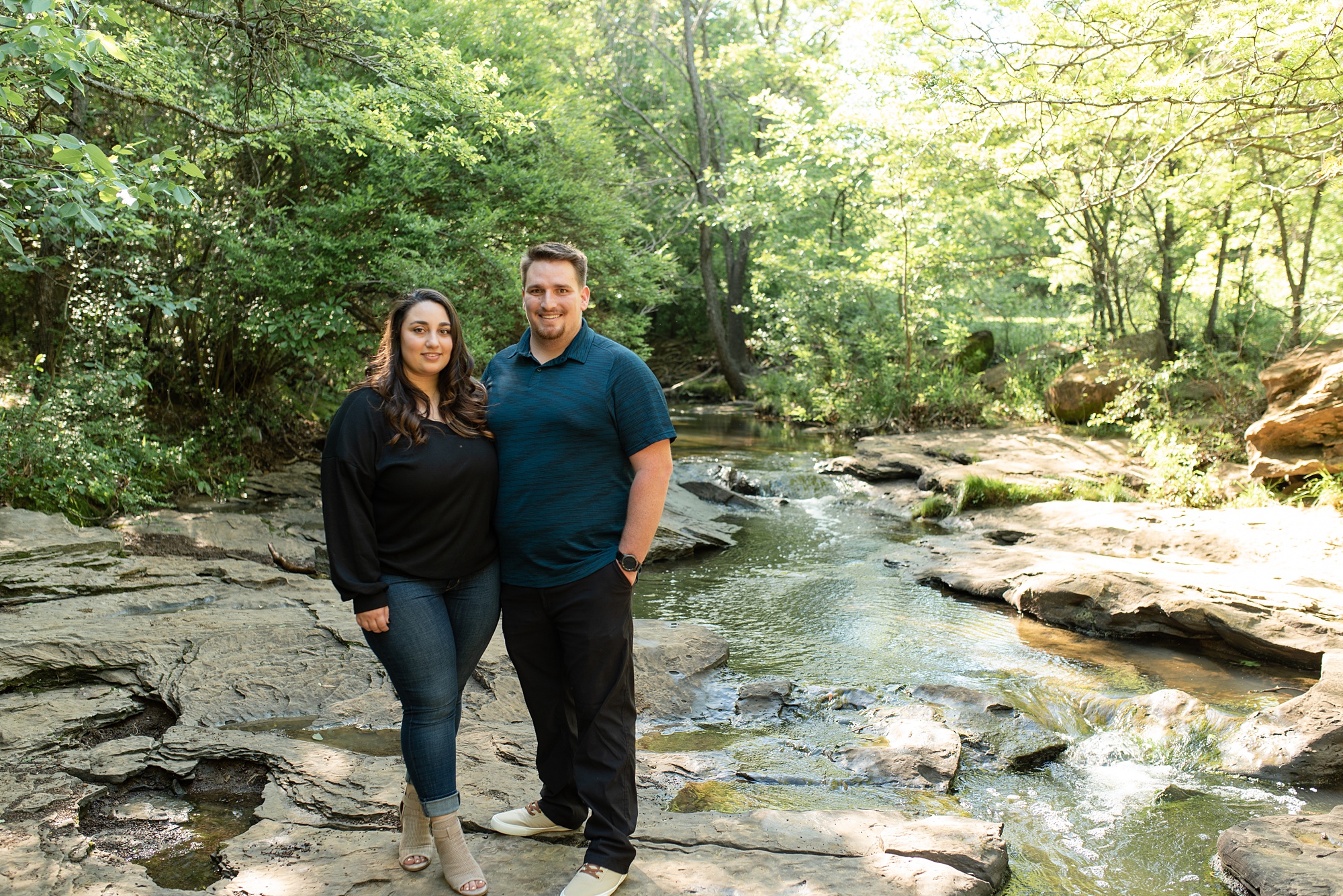 couple poses on rocks in Stone Creek Park