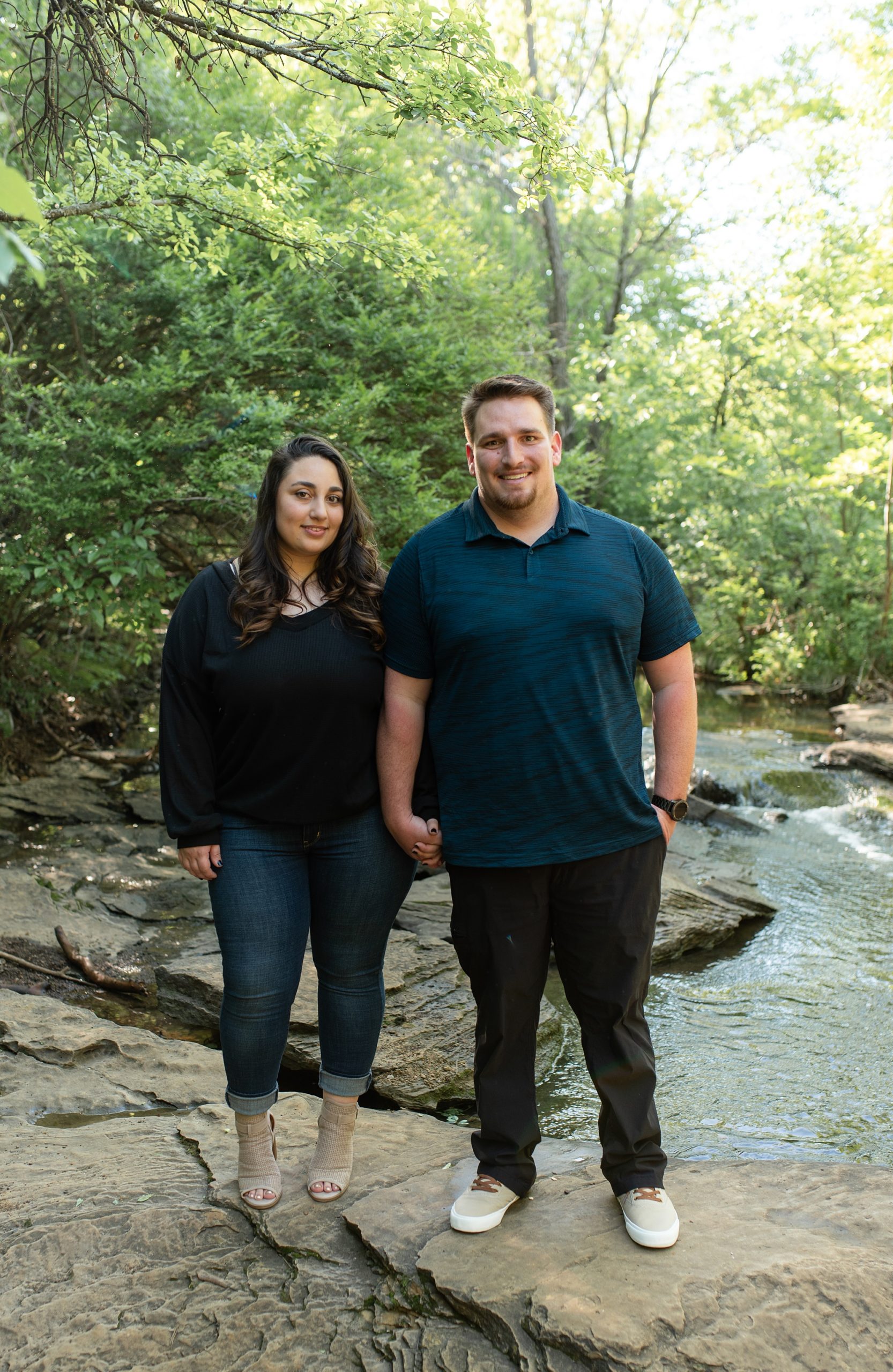 couple stands together on rocks in Stone Creek Park