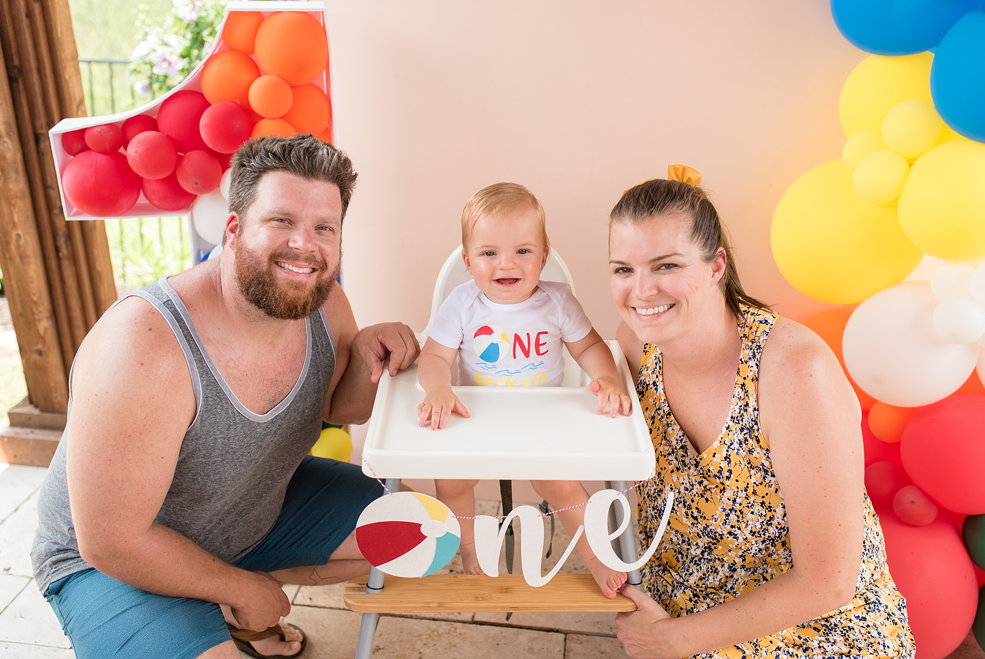 parents sit with one year old during cake smash