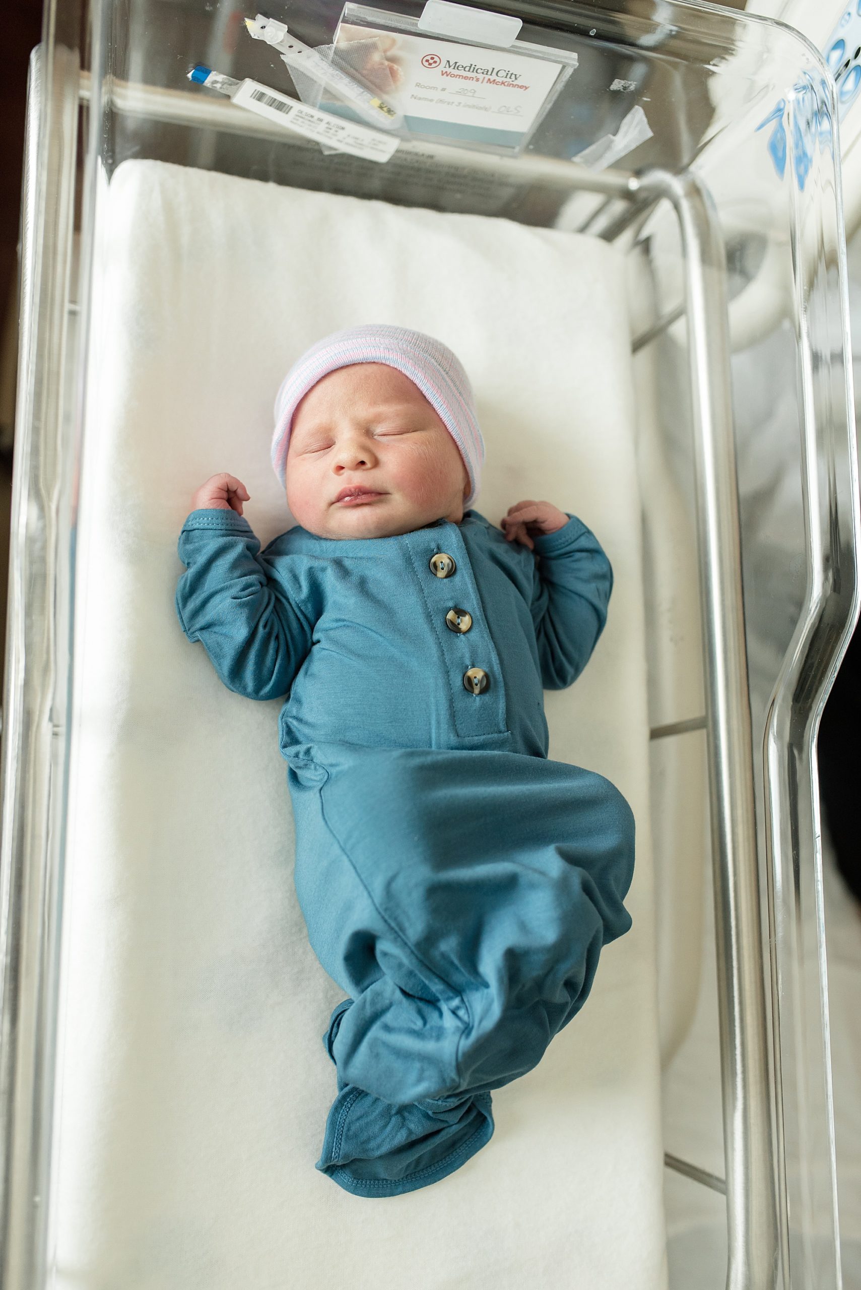 baby lays in blue sleeper during Fresh 48 hospital session