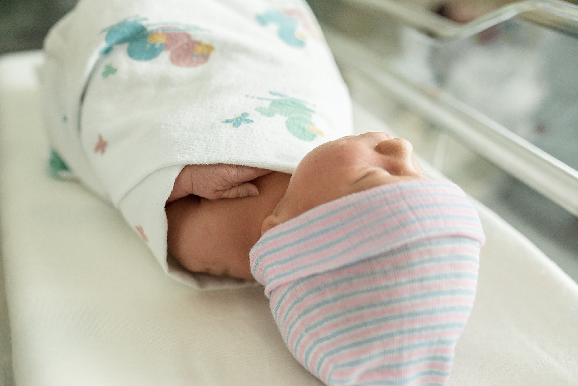 baby sleeps in hospital bassinet during newborn photos 