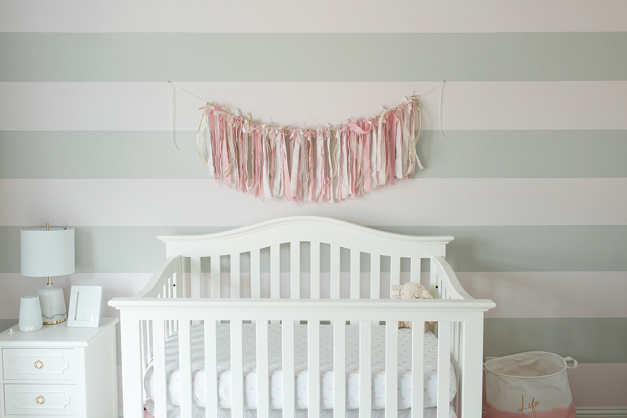 white crib with garland hanging above it in Texas nursery