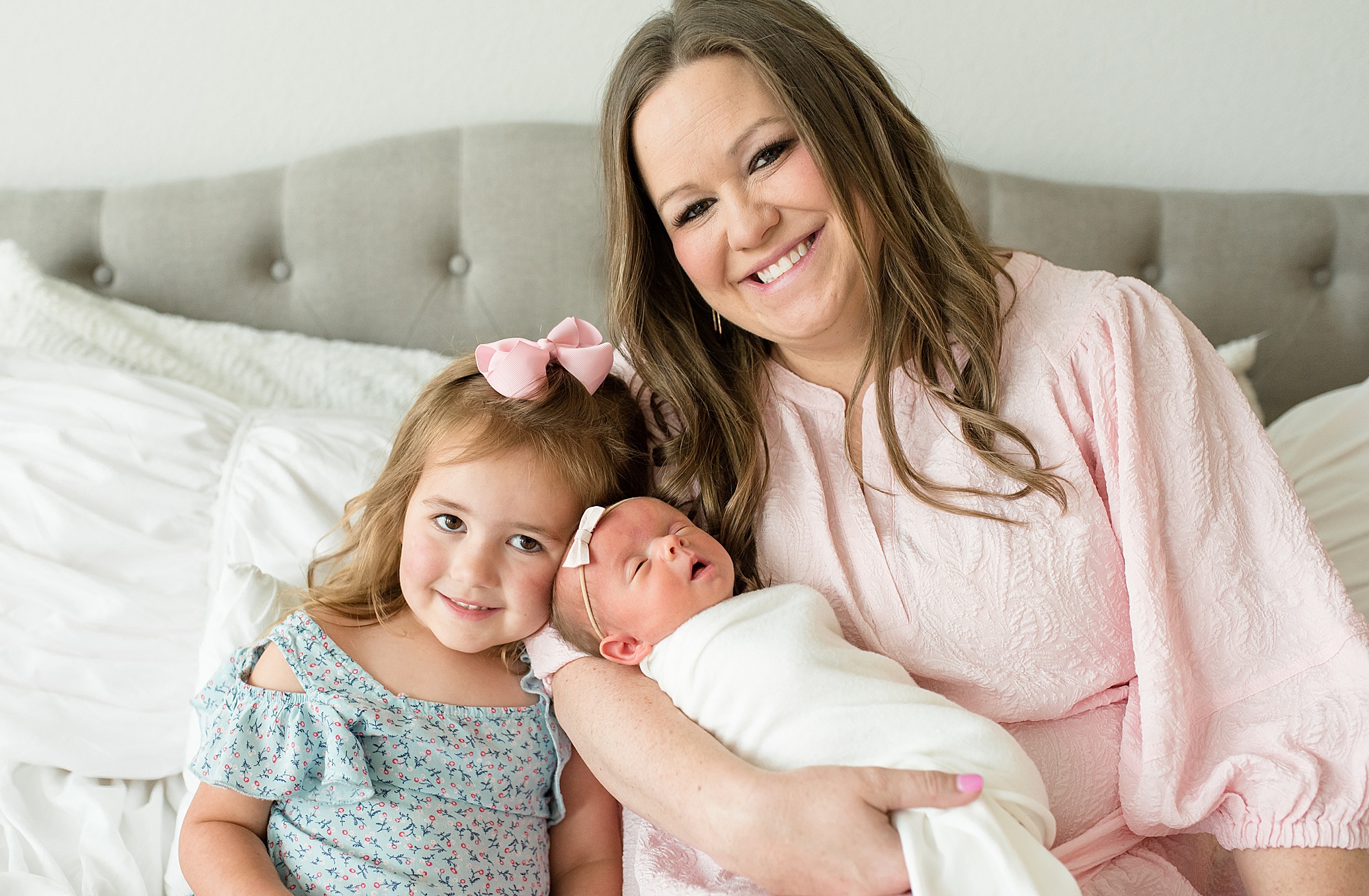 mom holds newborn baby girl during in-home lifestyle newborn session