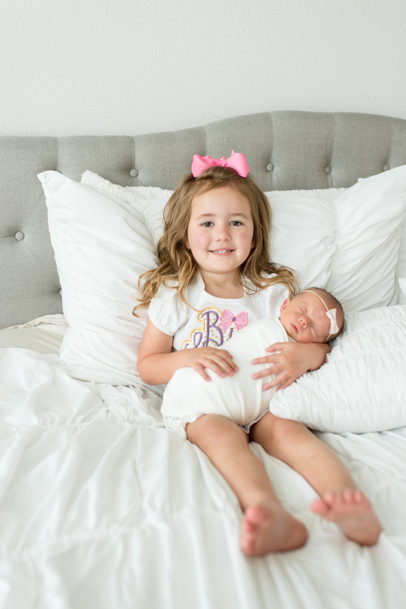 big sister holds newborn during in-home lifestyle newborn session