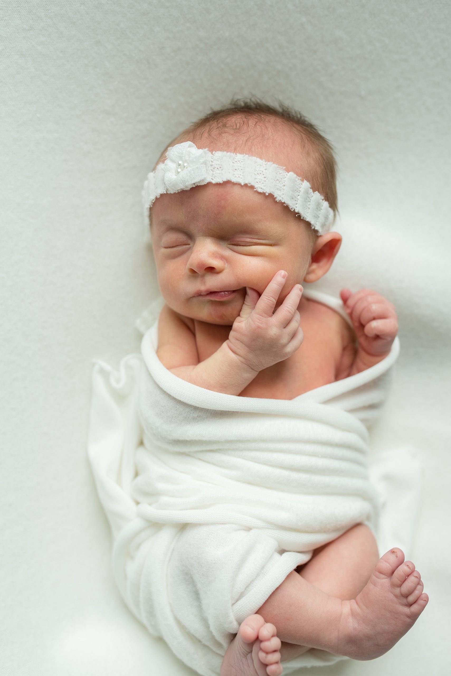 baby chews on finger during Texas newborn photos