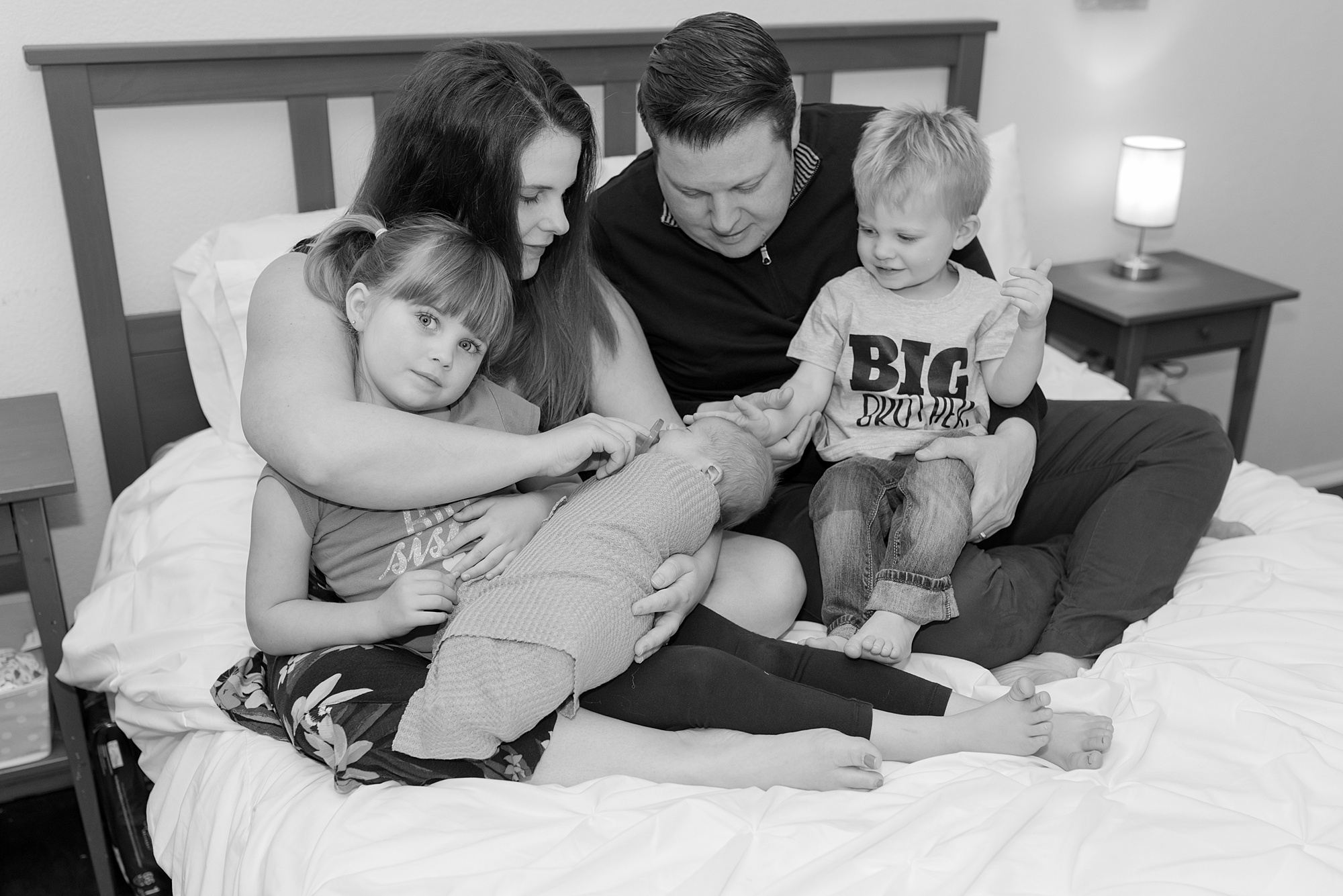 family of 5 snuggled on parents bed during in-home lifestyle family session