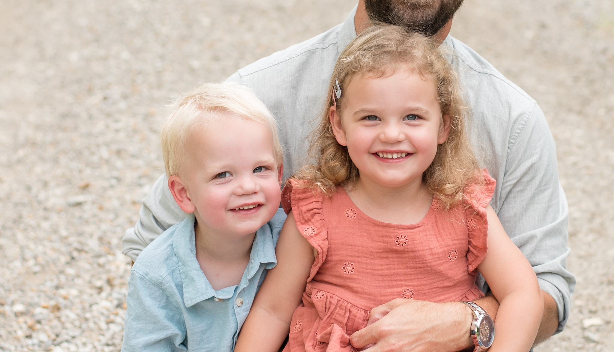 brother and sister smile up at camera during family portraits