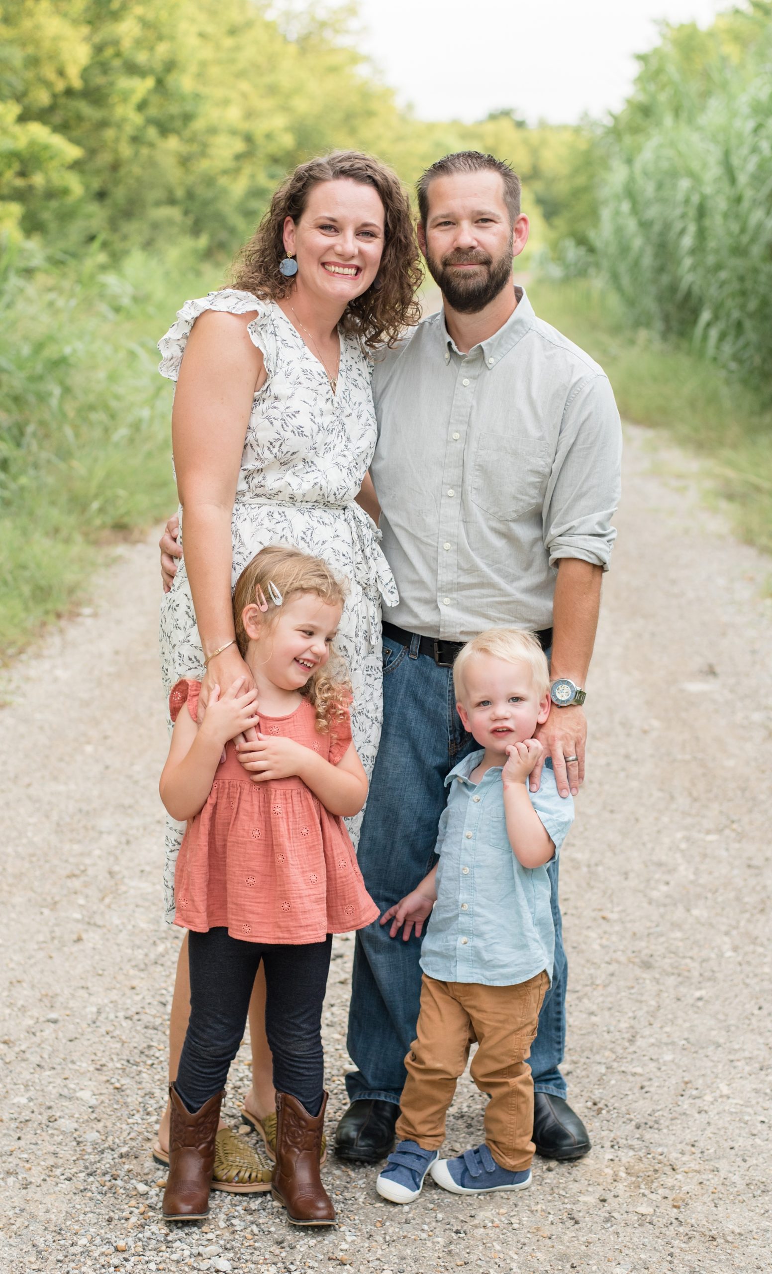 family stands together in gravel road in Texas