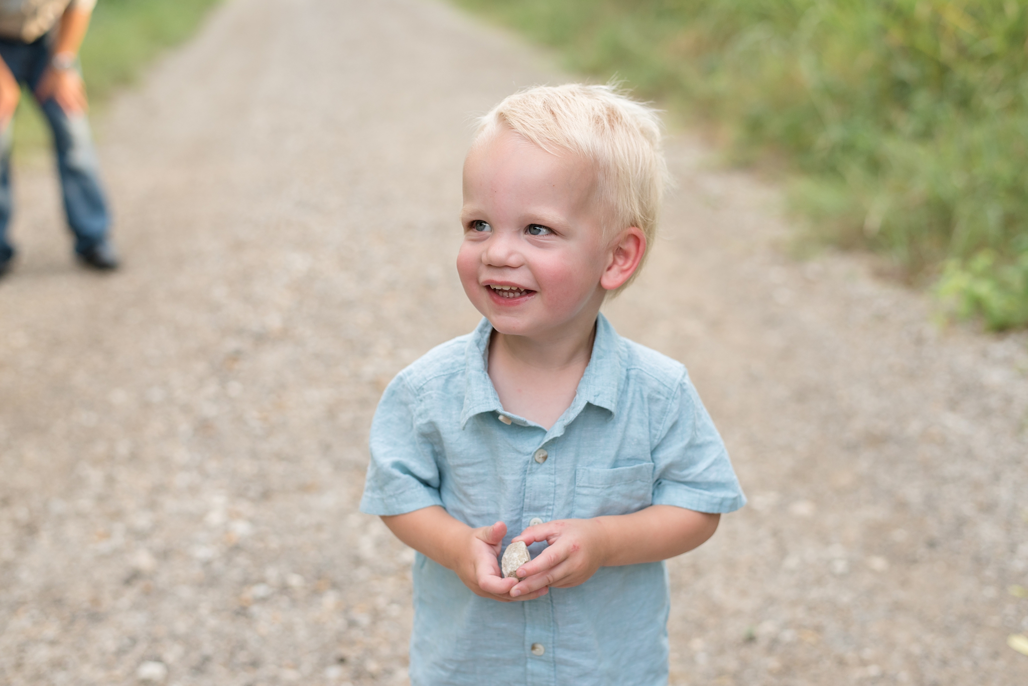 little boy smiles as he holds rock during portraits