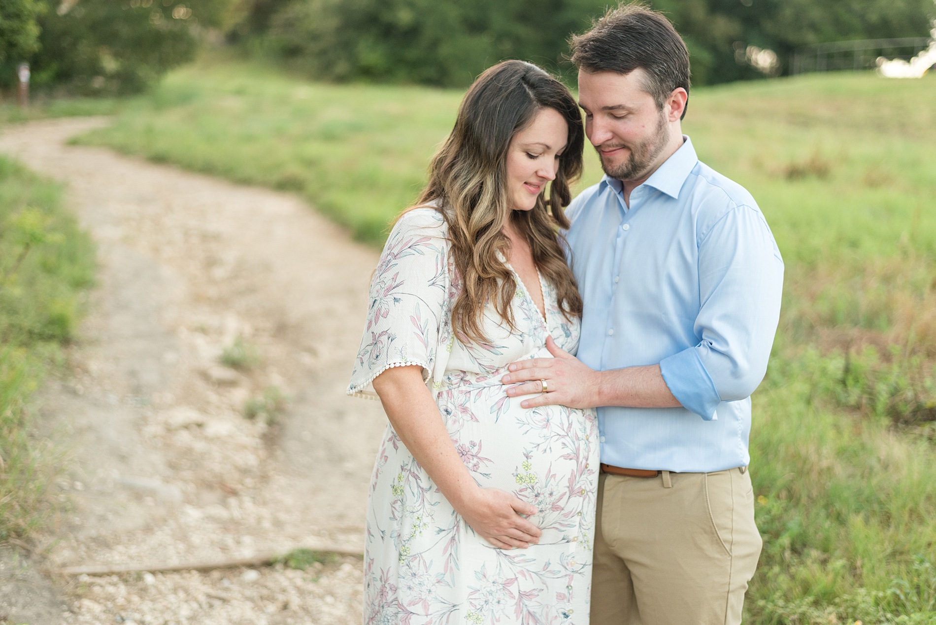couple looks down at pregnant belly