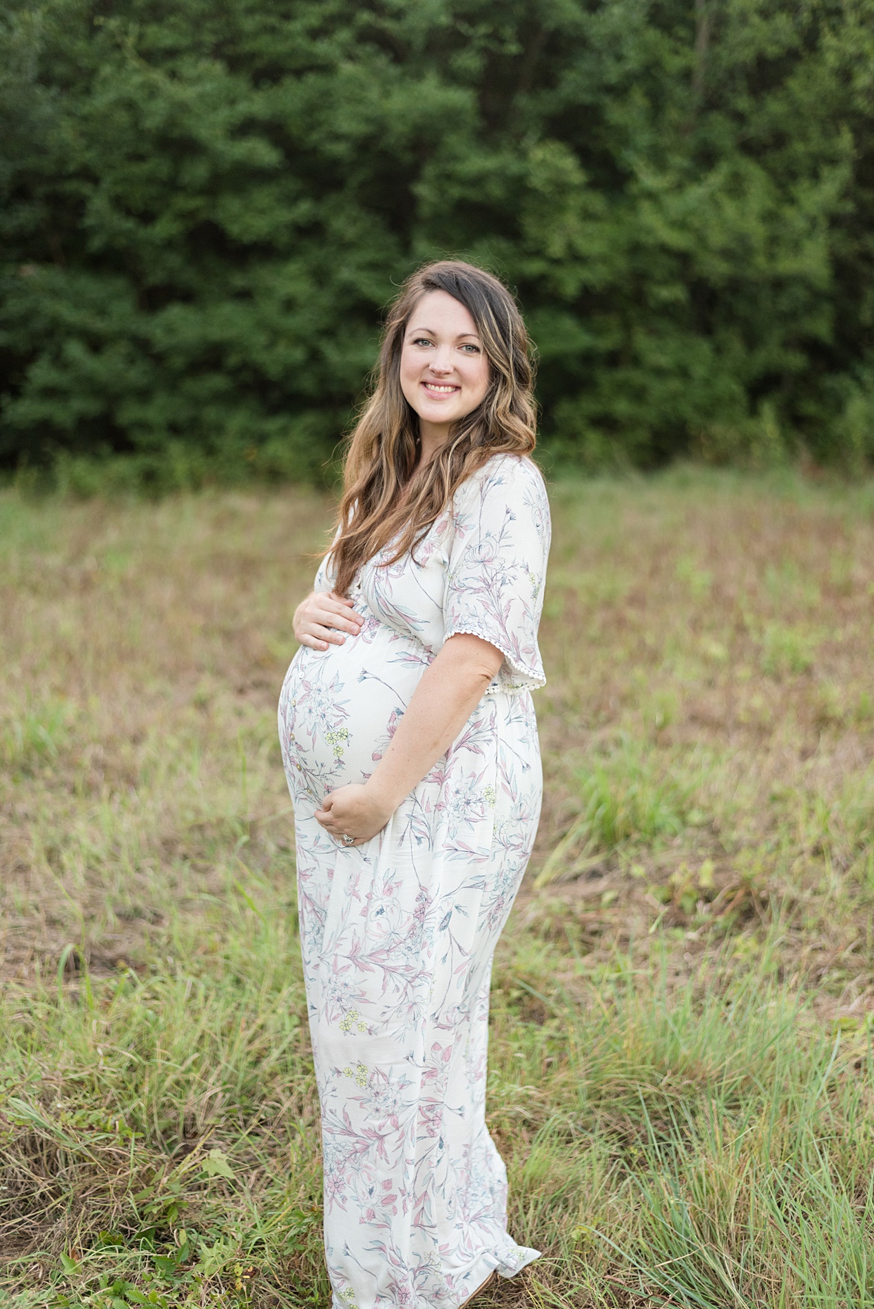 mom to be holds baby bump for maternity portrait 