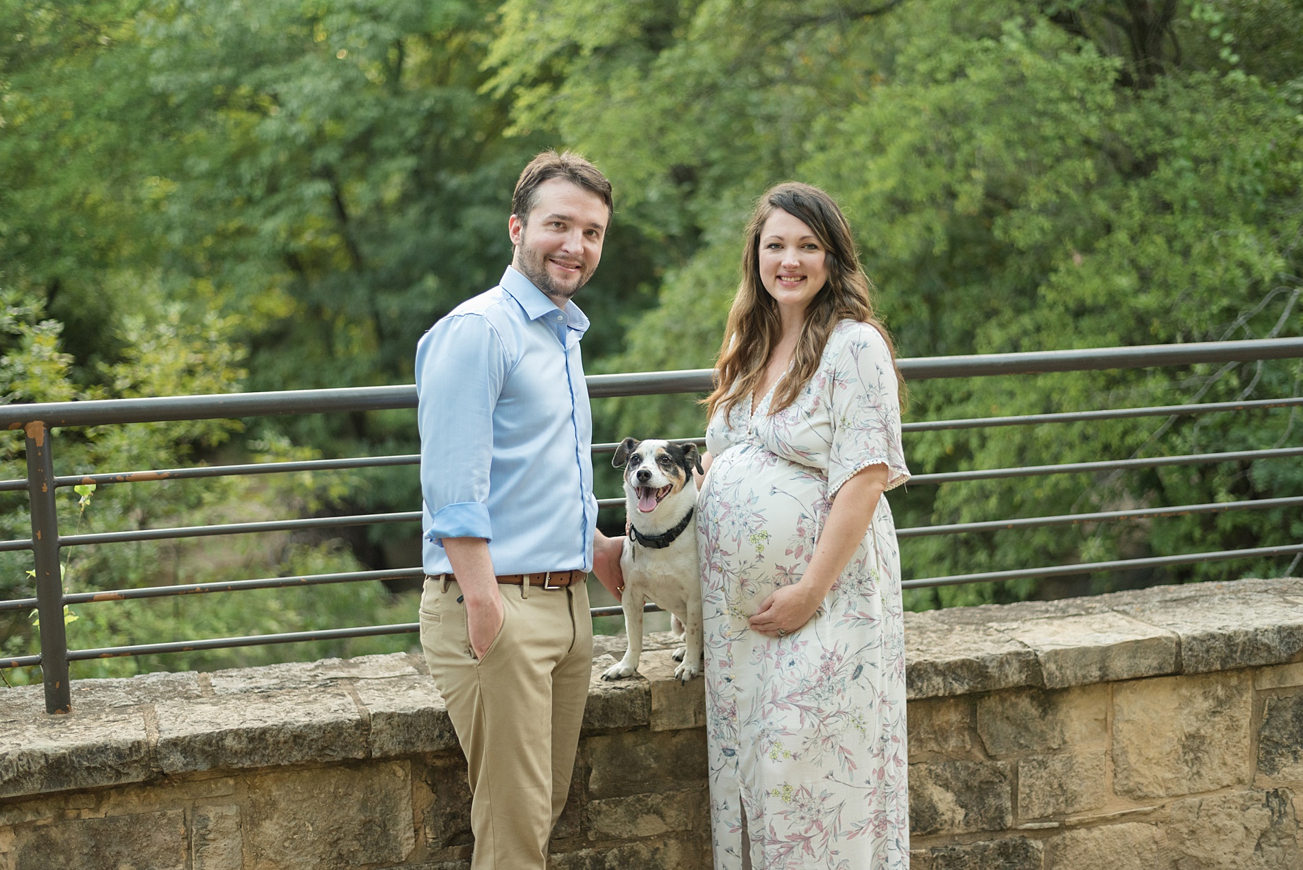 couple stand with their dog on bridge at Arbor Hills in TX 