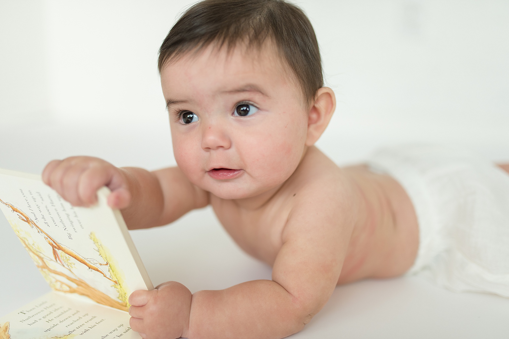 baby boy playing with favorite board book