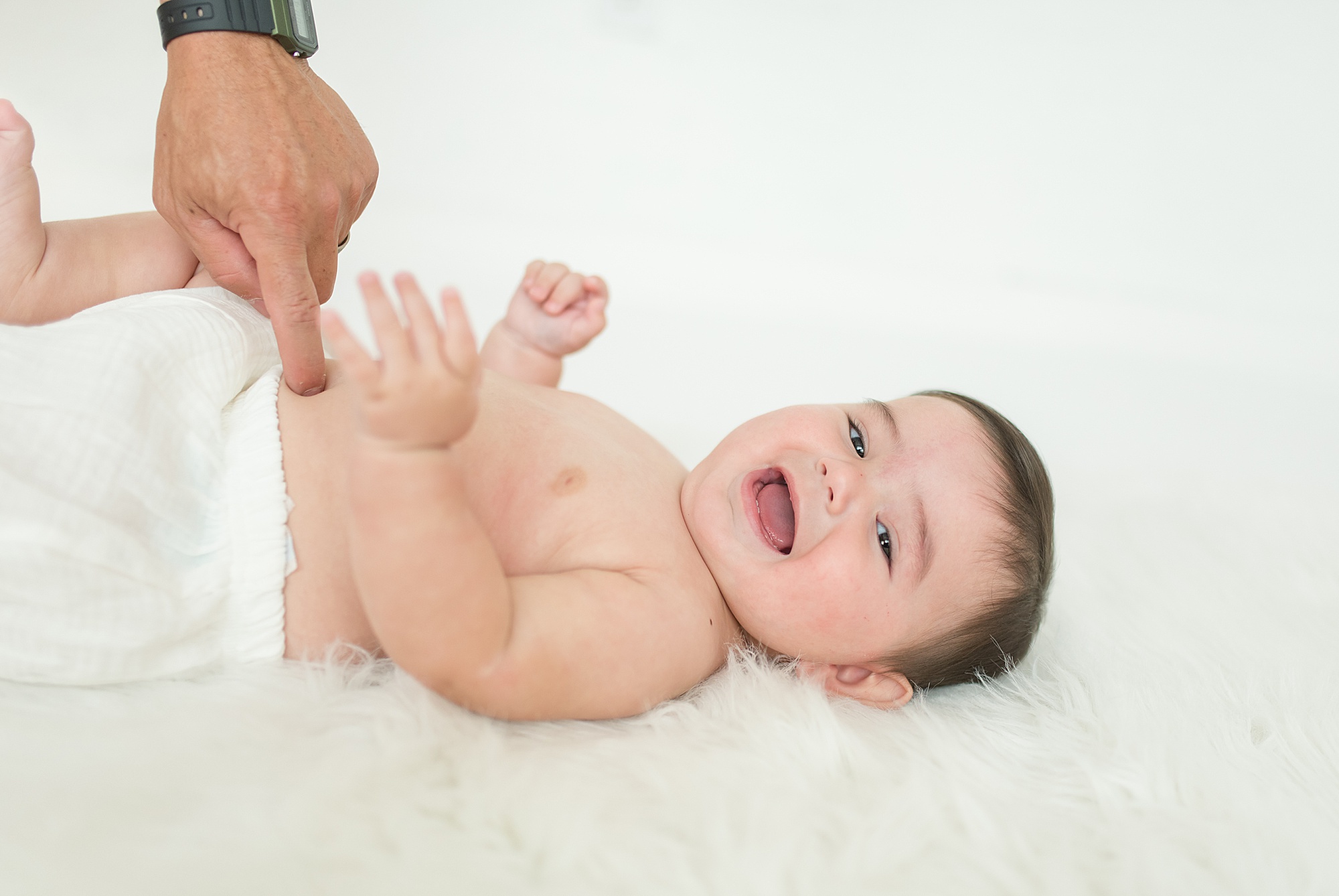 baby boy laughs as he is tickled during photo session