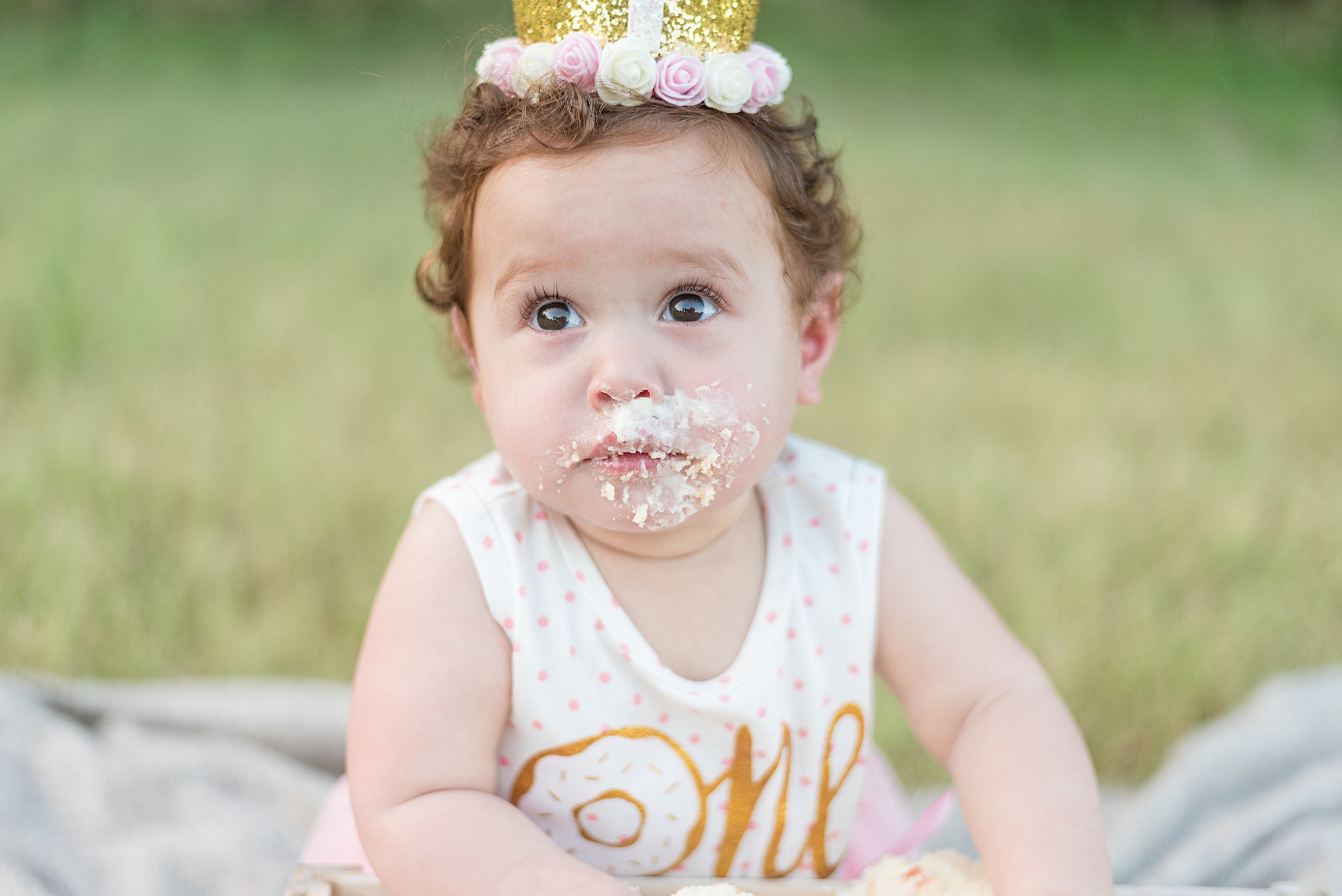 little girl with icing on her face during cake smash