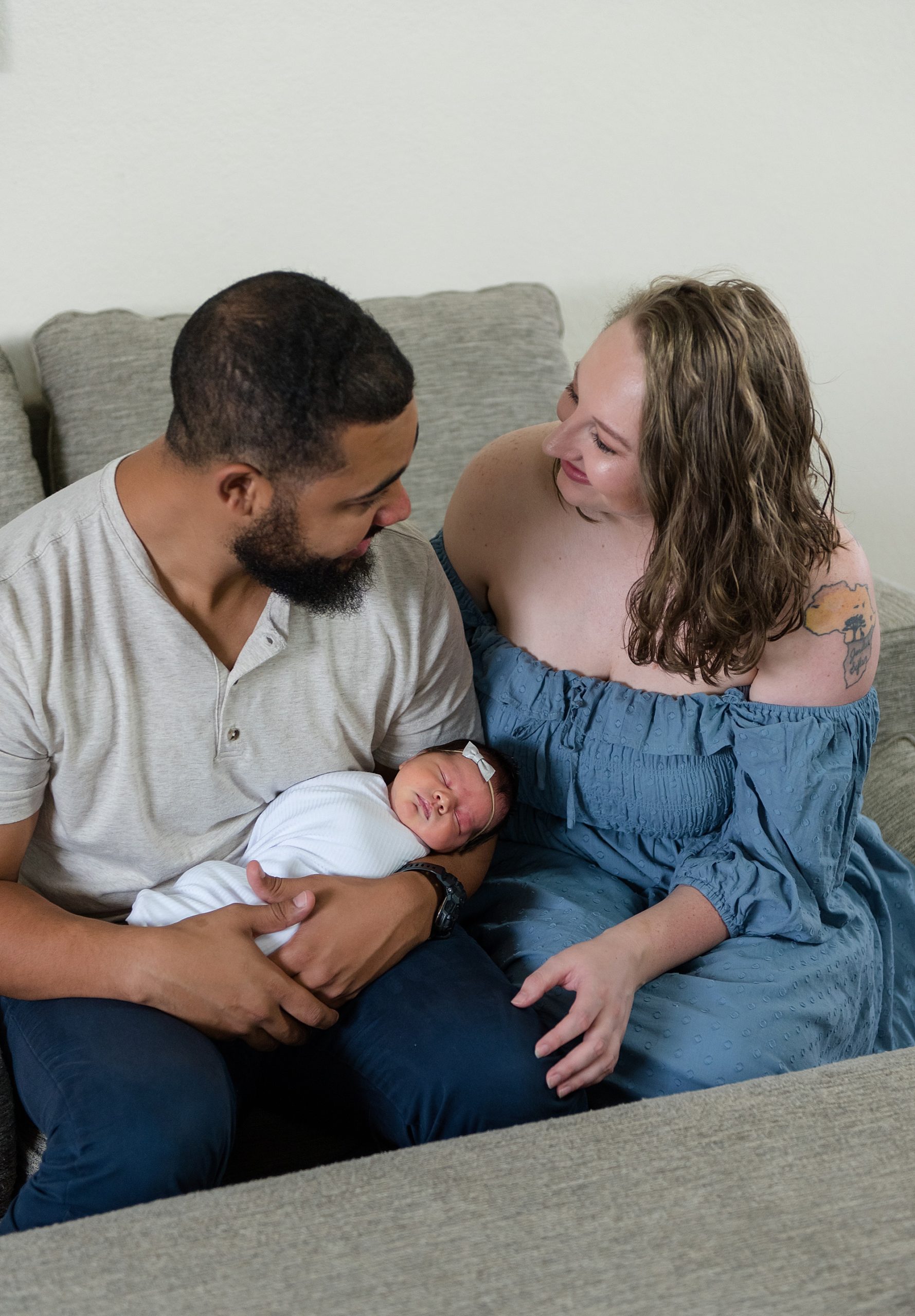 mom and dad hold newborn girl