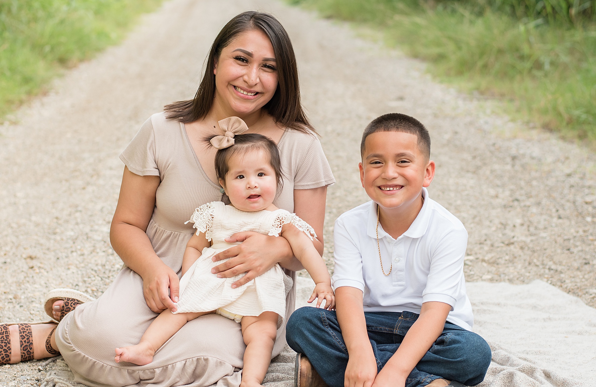mom holds baby girl sitting next to her son during Little Elm TX family session