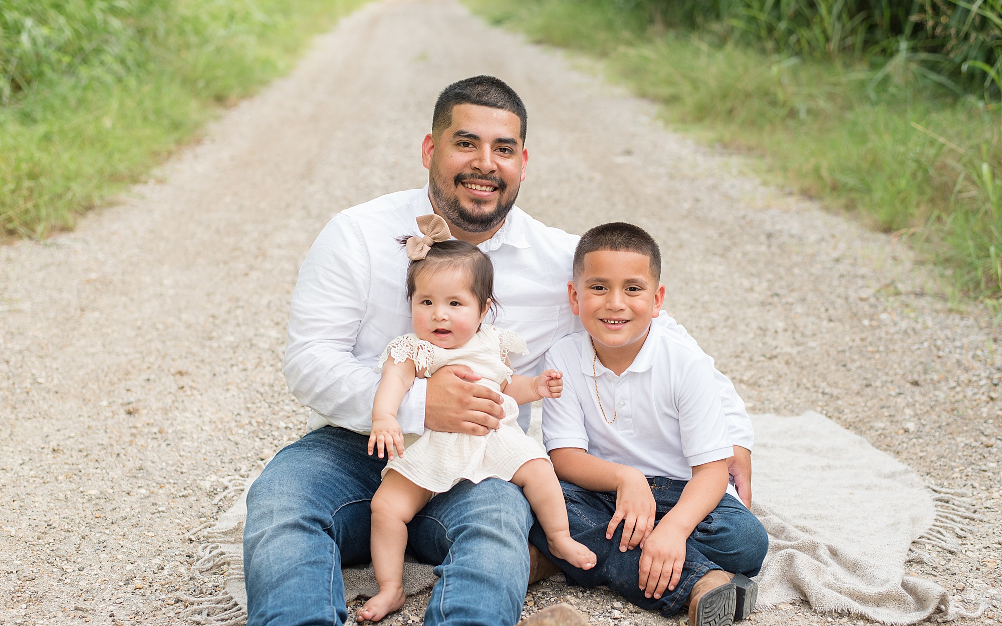 dad holds baby girl sitting next to her son during Little Elm TX family session