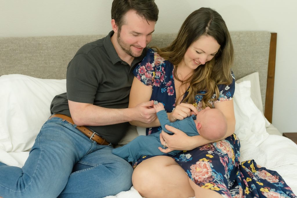 New parents admire their newborn baby boy during in-home newborn session in TX
