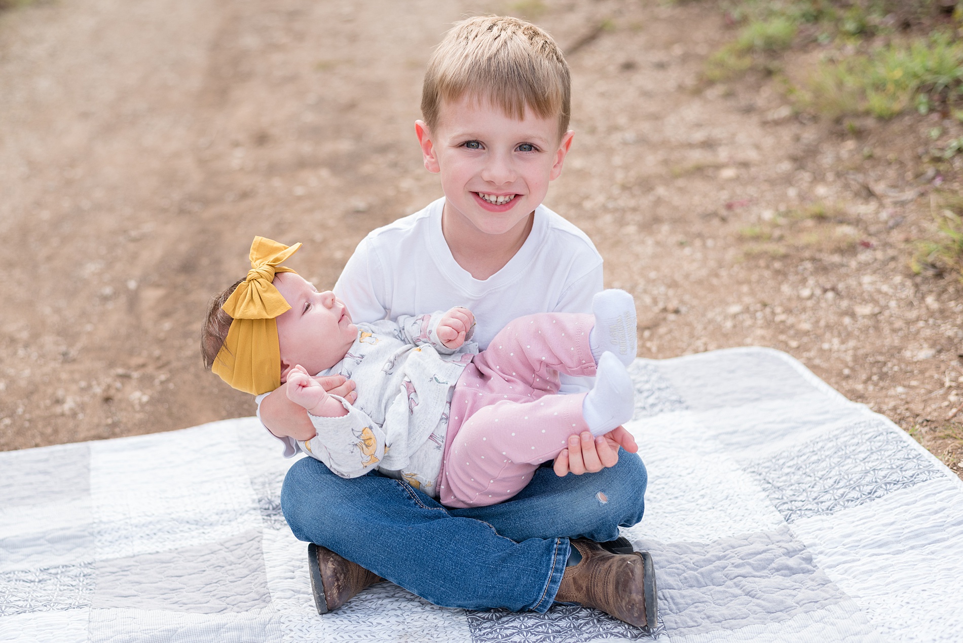 big brother holds his little sister outside during fall family photos in TX