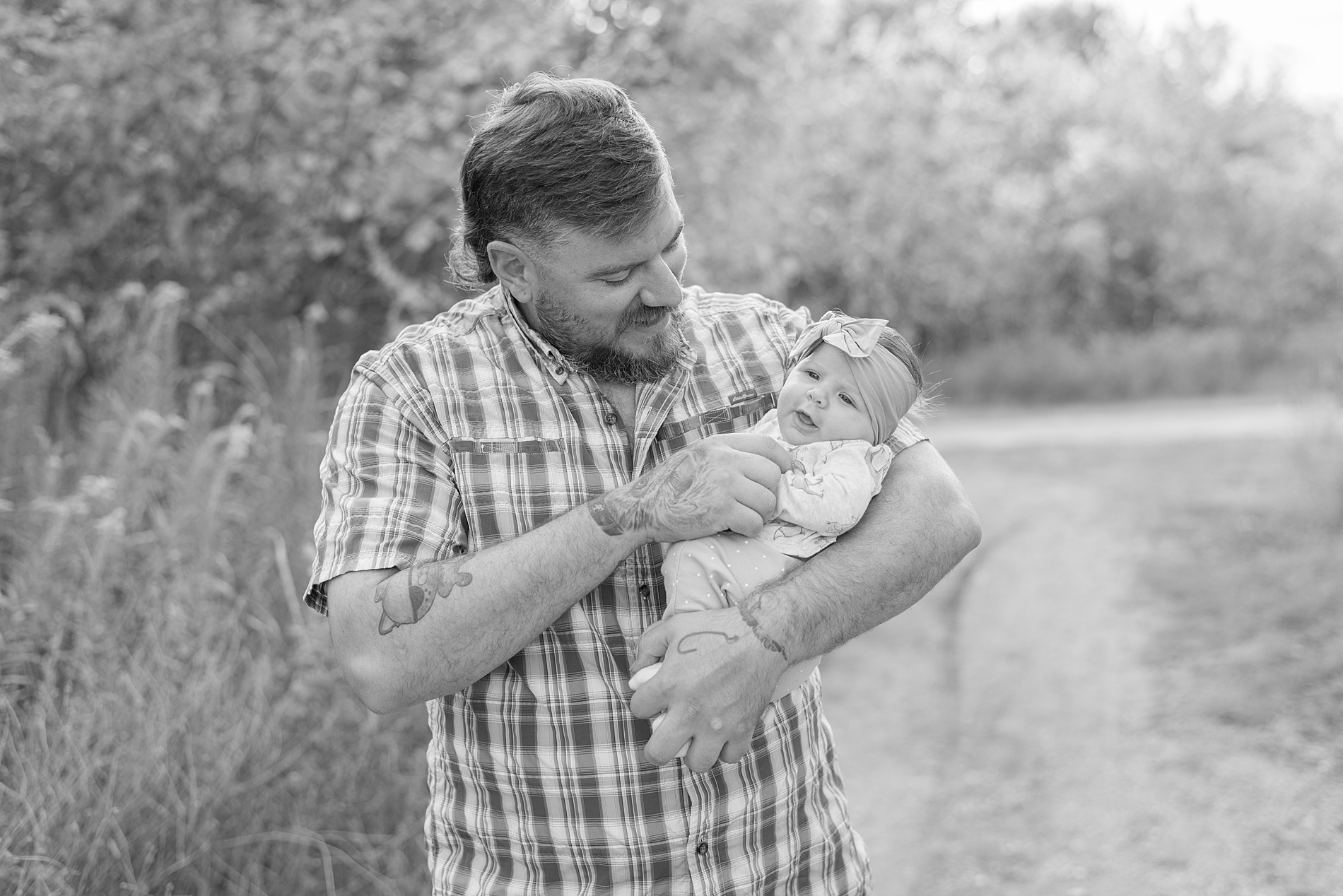 black and white photo of dad holding baby girl 