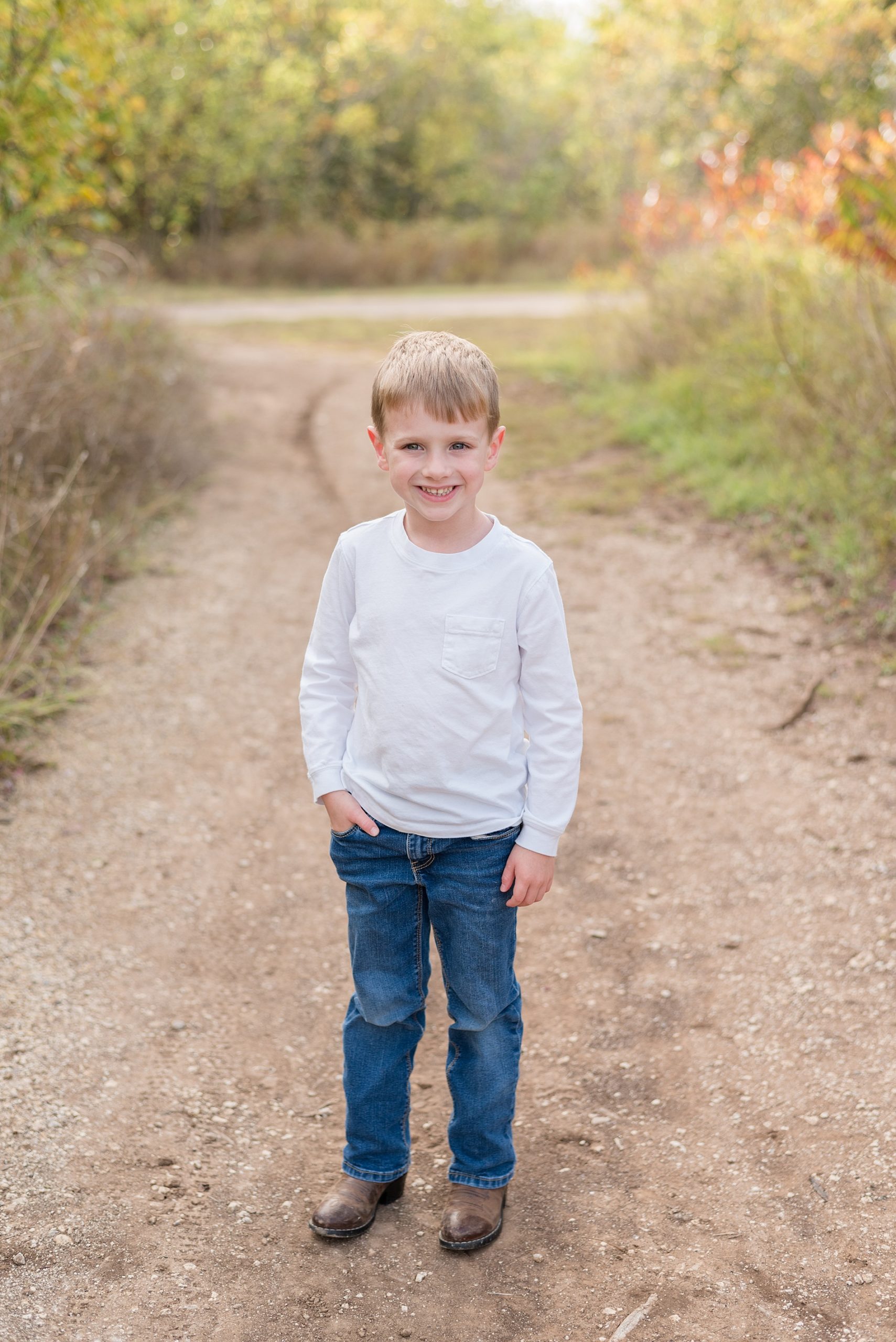 big brother poses on the walking path in Frisco Texas fall photos