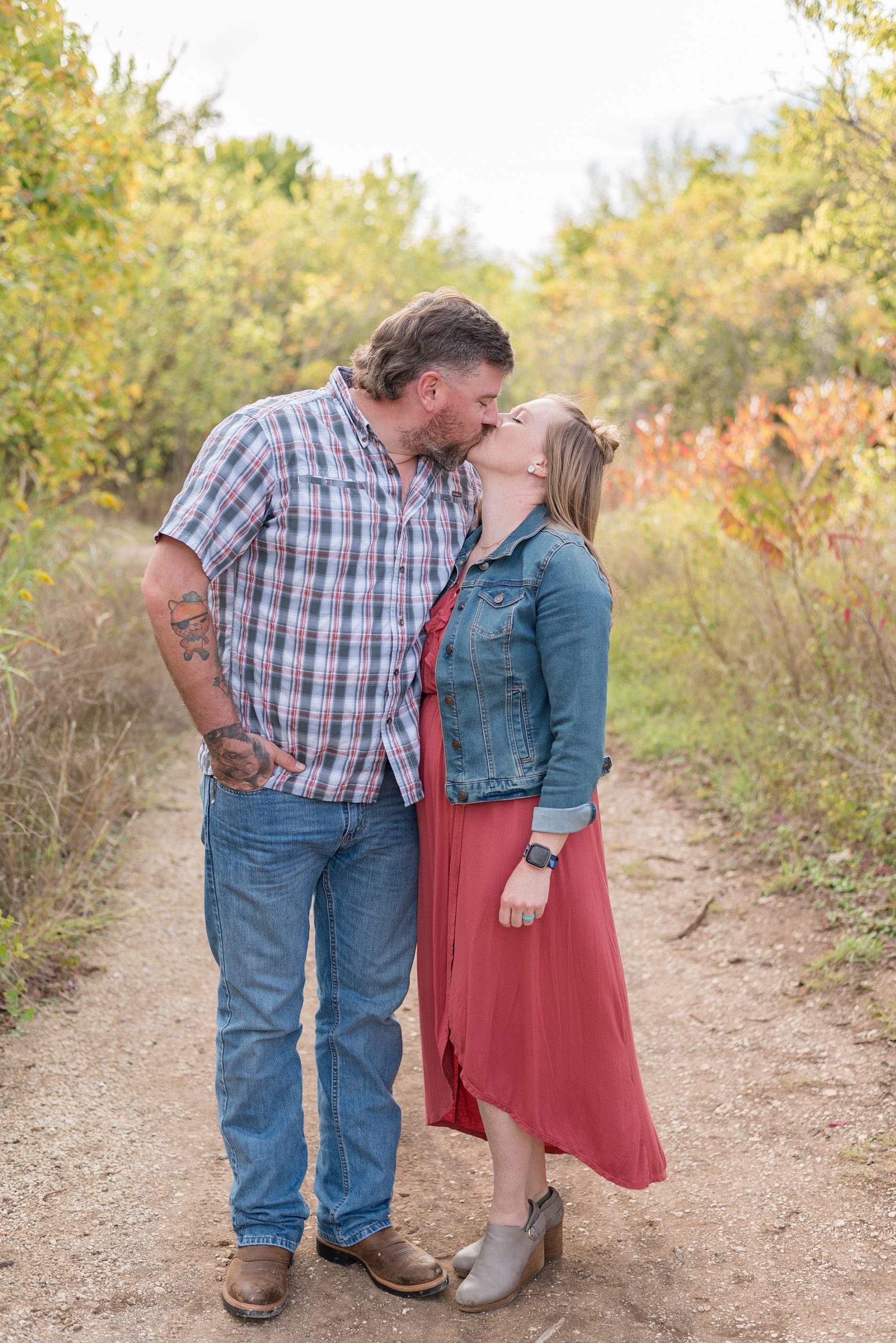 husband and wife kiss during fall photos