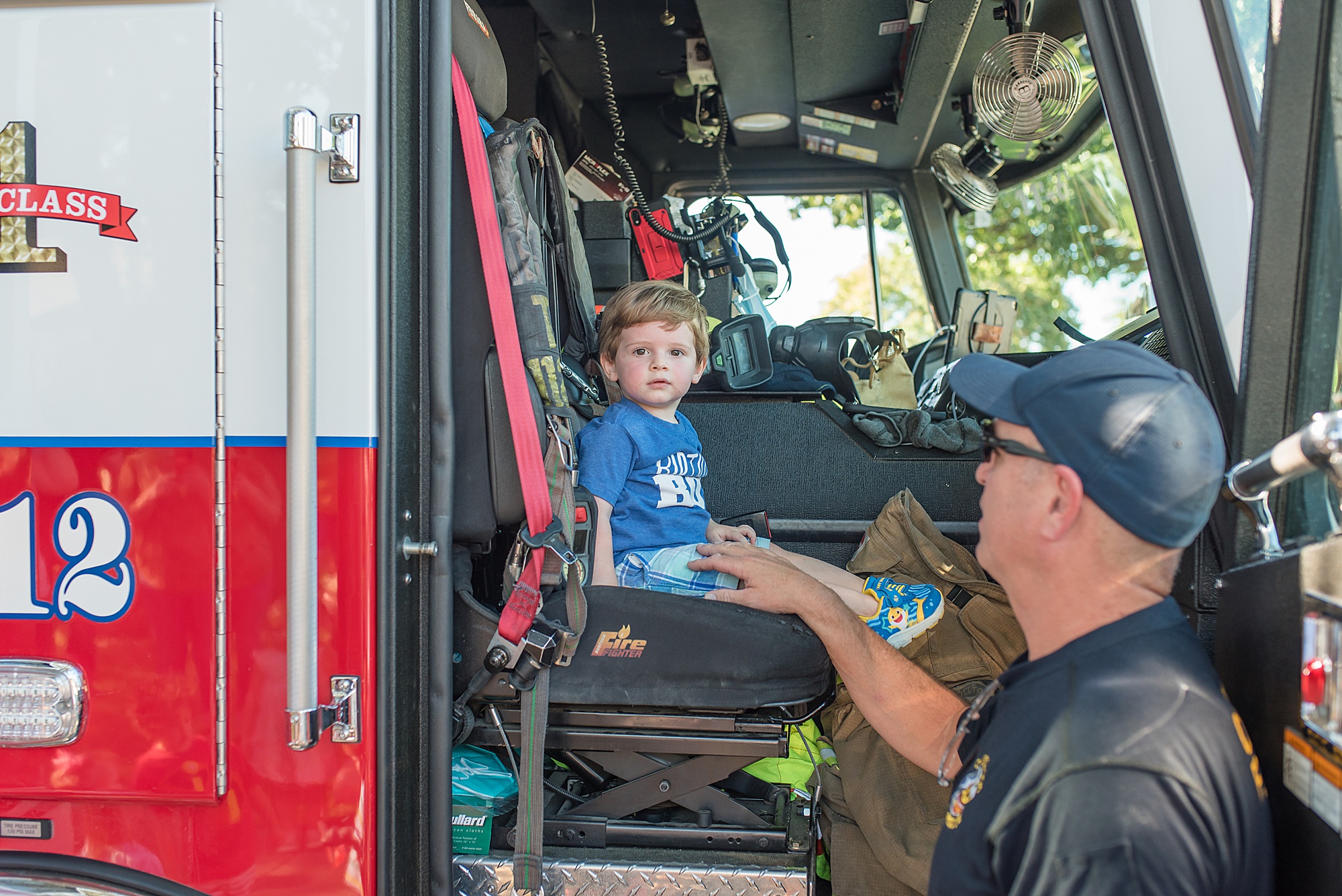 Little boy sits in Fire engine at Second Birthday Party